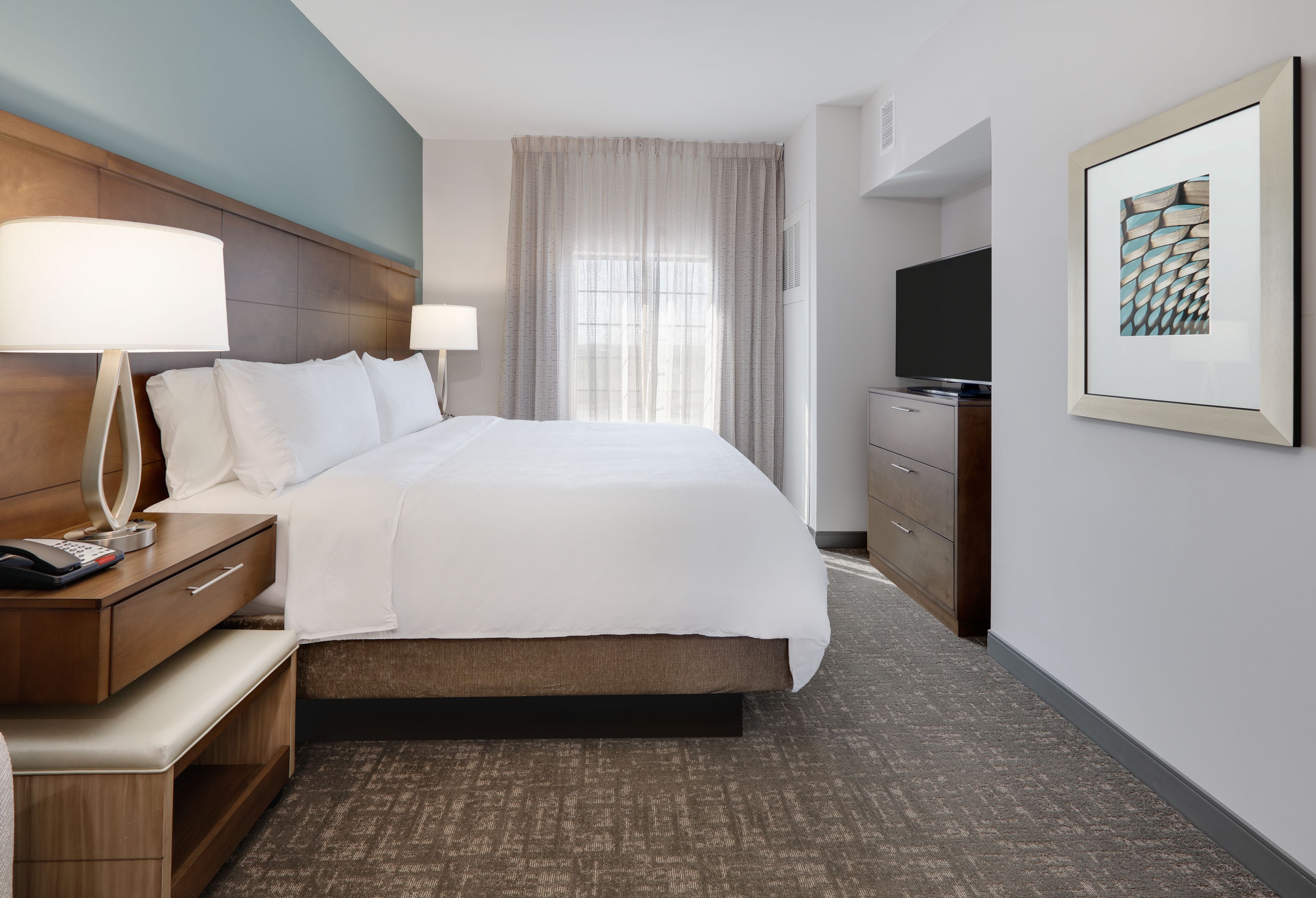 image Serene king bedroom with plush bed and inviting natural light.