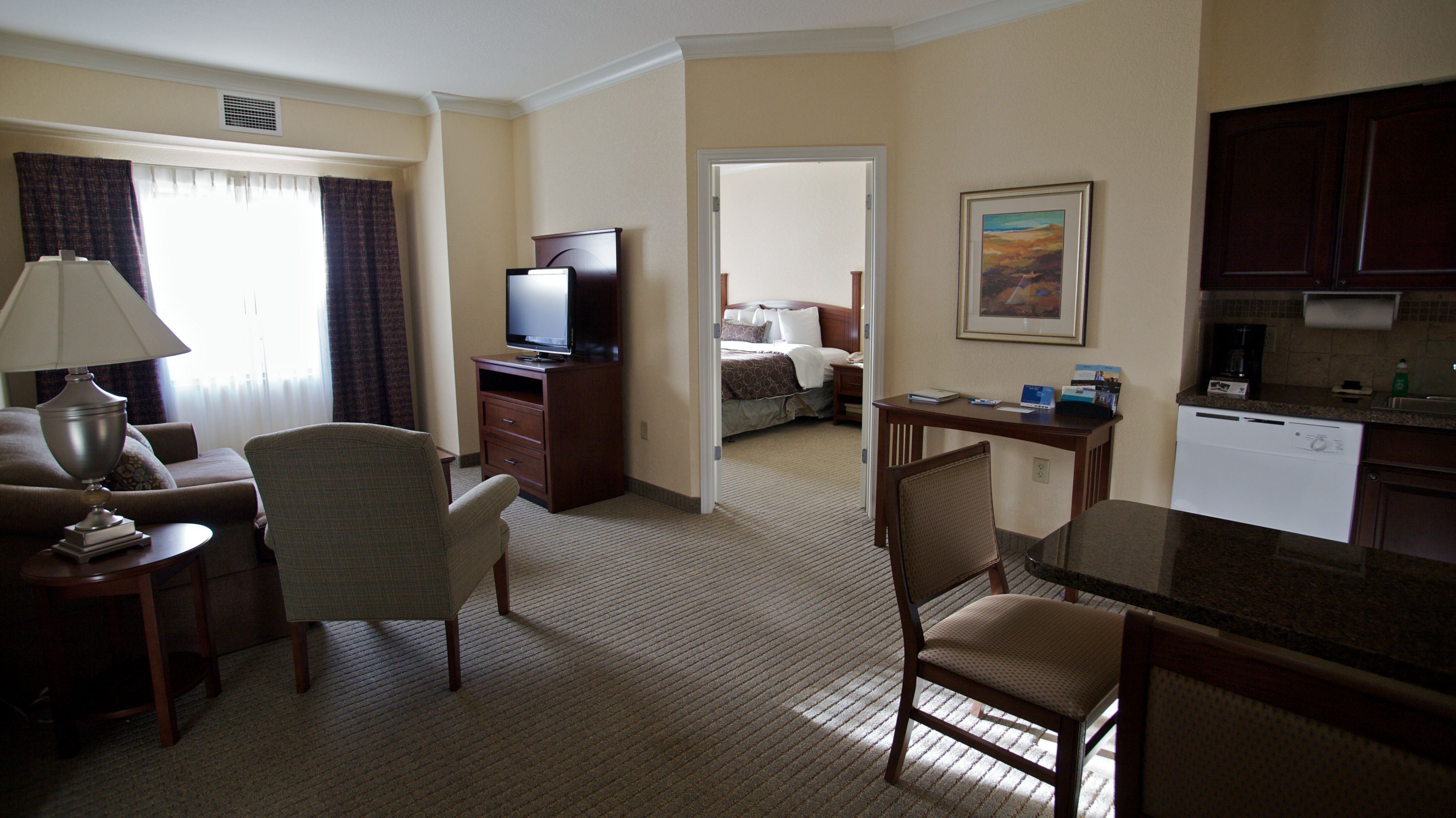 image Inviting suite with comfortable seating and open bedroom view.