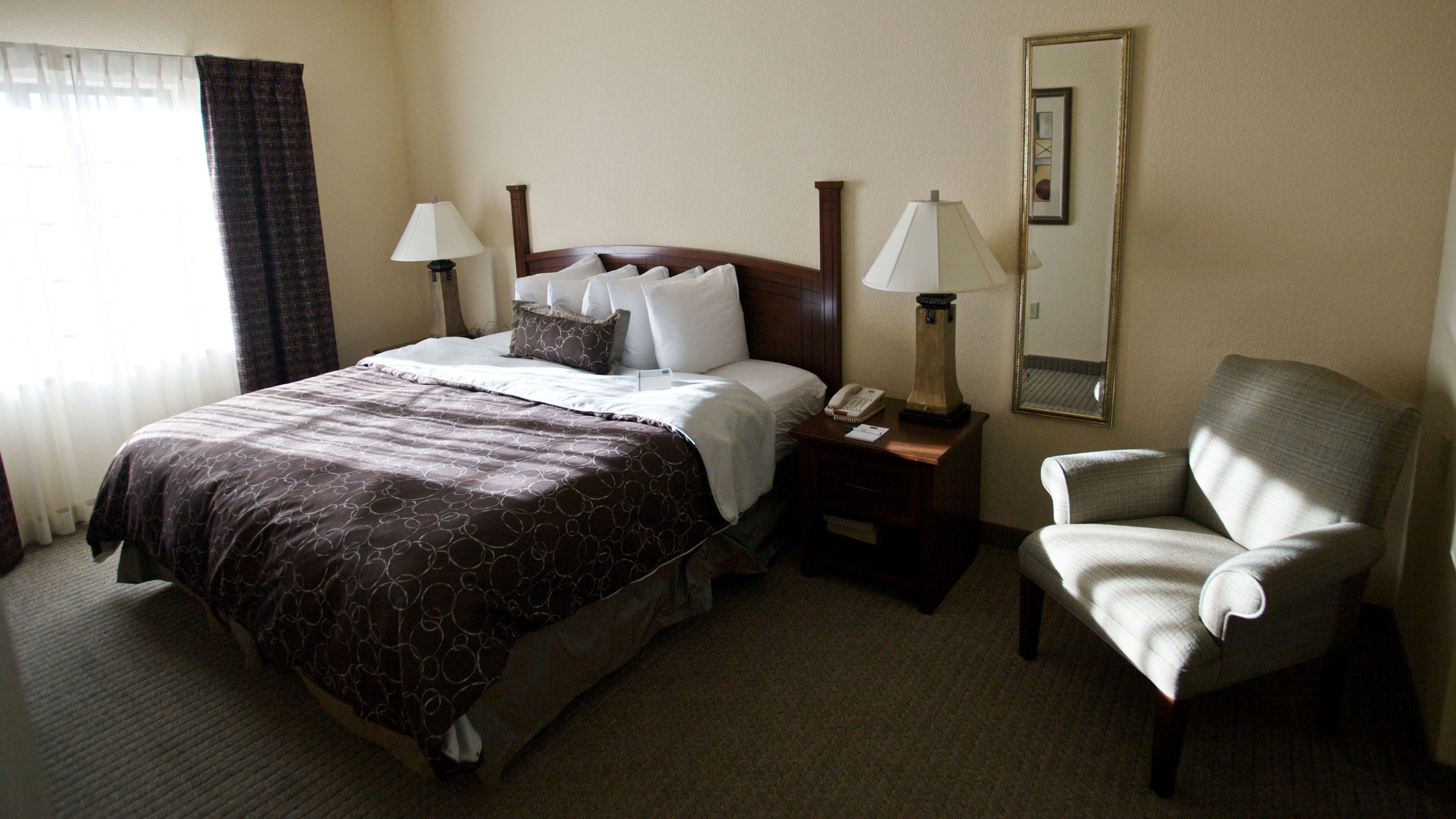 image Cozy bedroom featuring plush bedding and ample natural light.