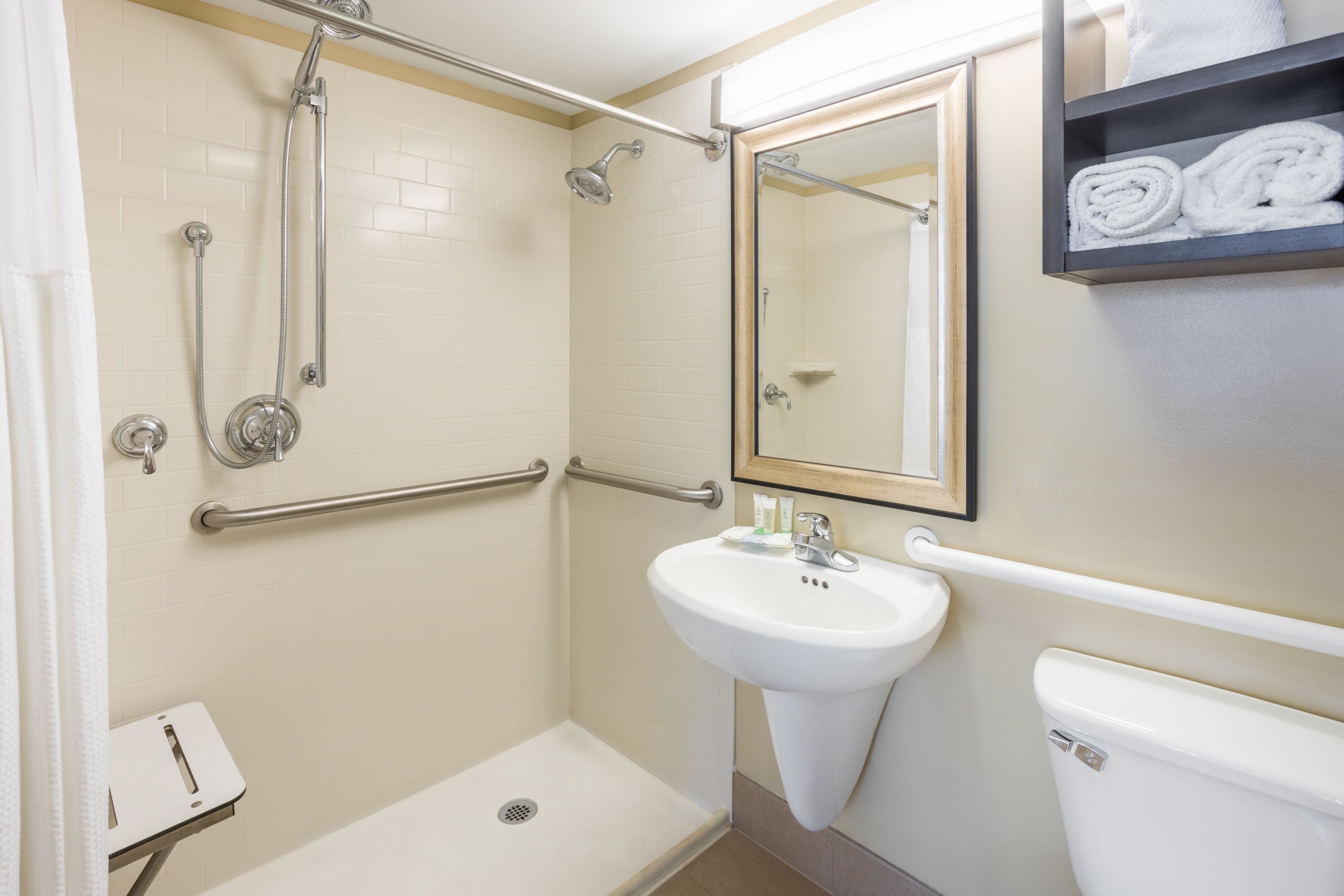 image Accessible bathroom with a roll-in shower, sink, and open layout designed for ease of movement.