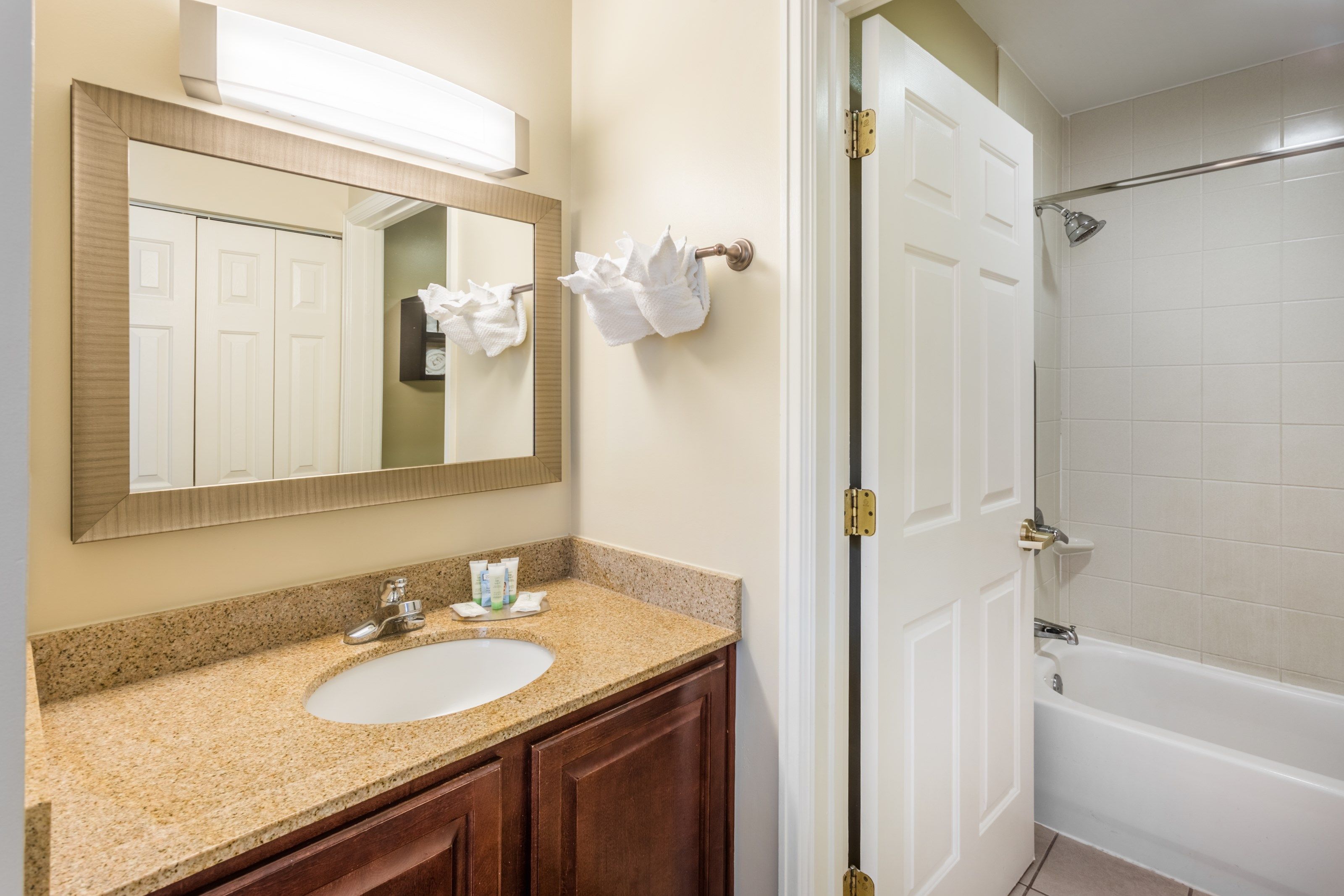image Bathroom with shower, sink, vanity mirror, and towels.