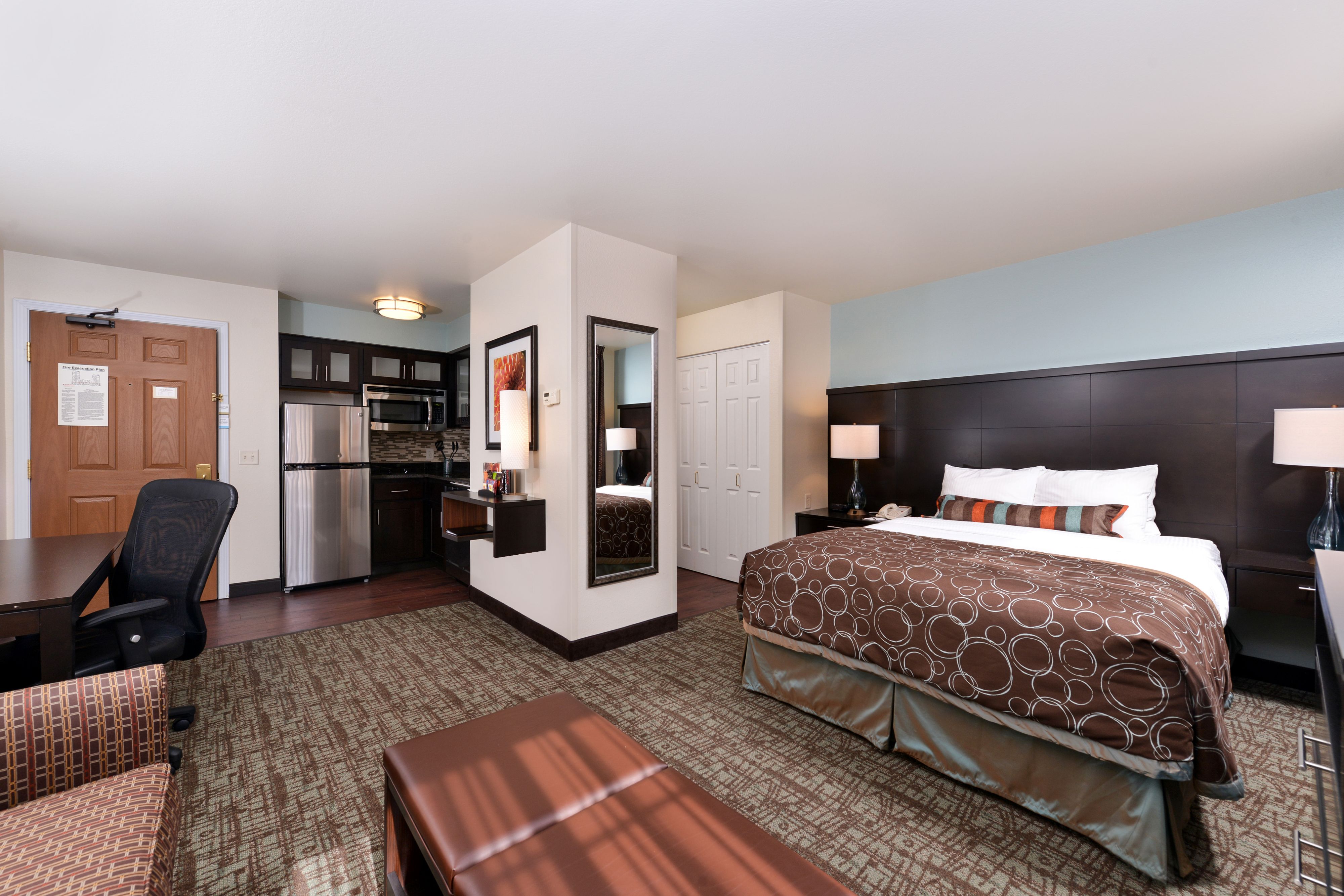 image Comfortable suite with a queen bed and kitchenette.