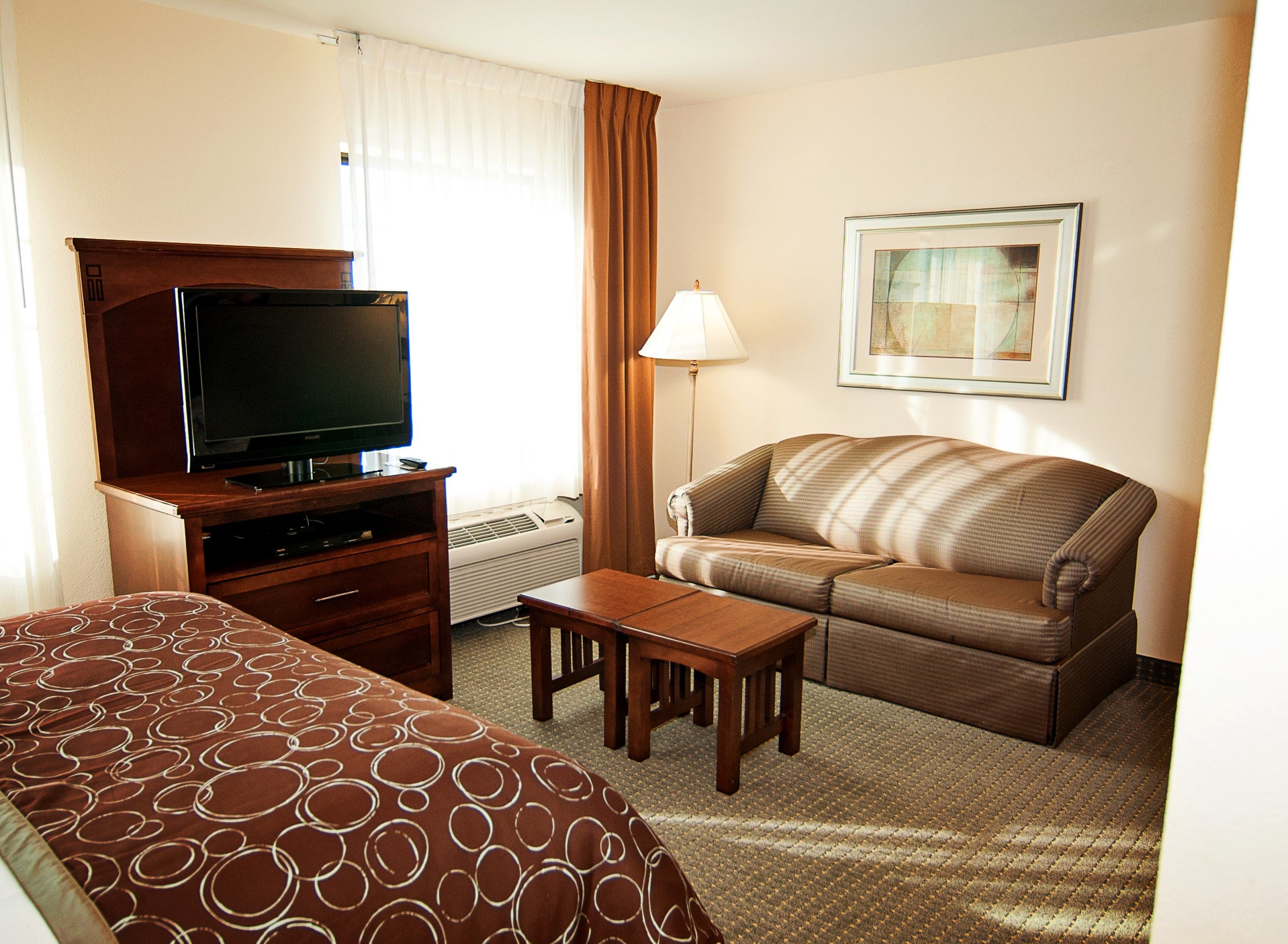 image Open studio with Queen bed, sofa, two coffee tables, flatscreen TV, and natural light from the window