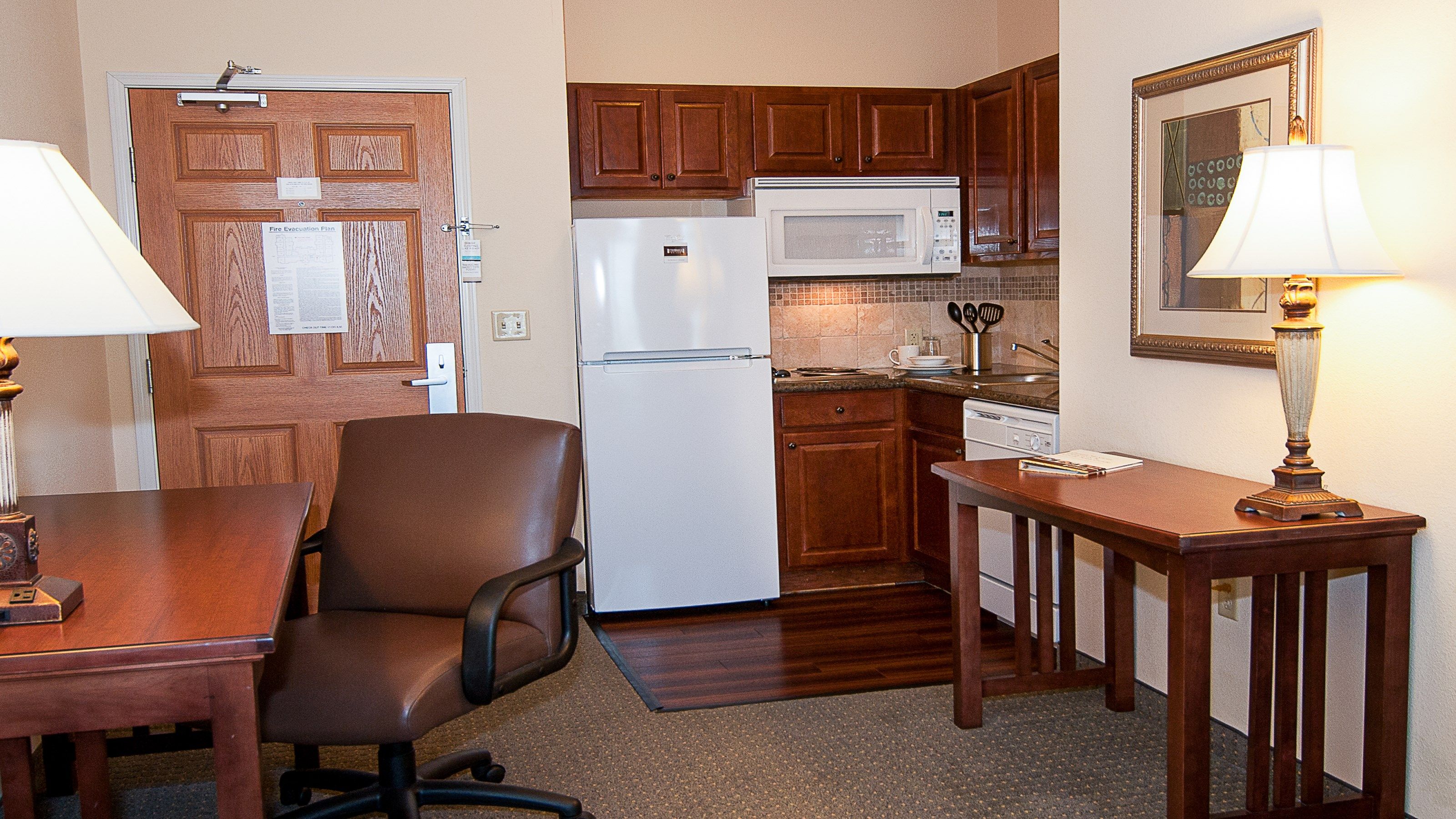 image Full kitchen with granite countertop, stainless steel appliances, and dedicated workspace with desk and chair