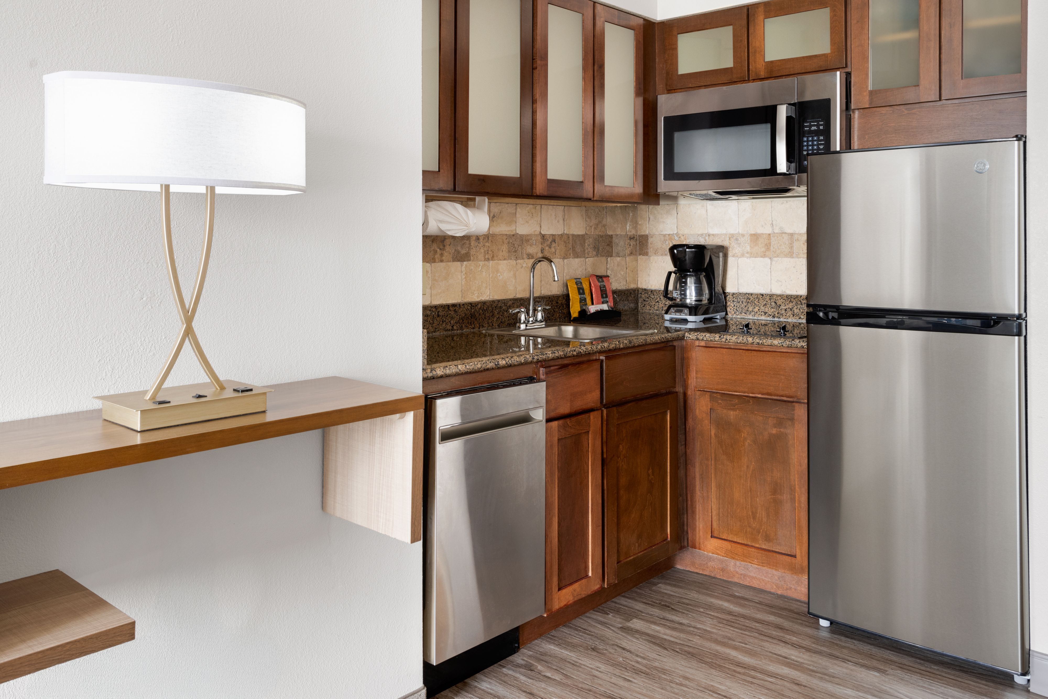 image Modern kitchenette with stainless steel appliances and granite countertops.