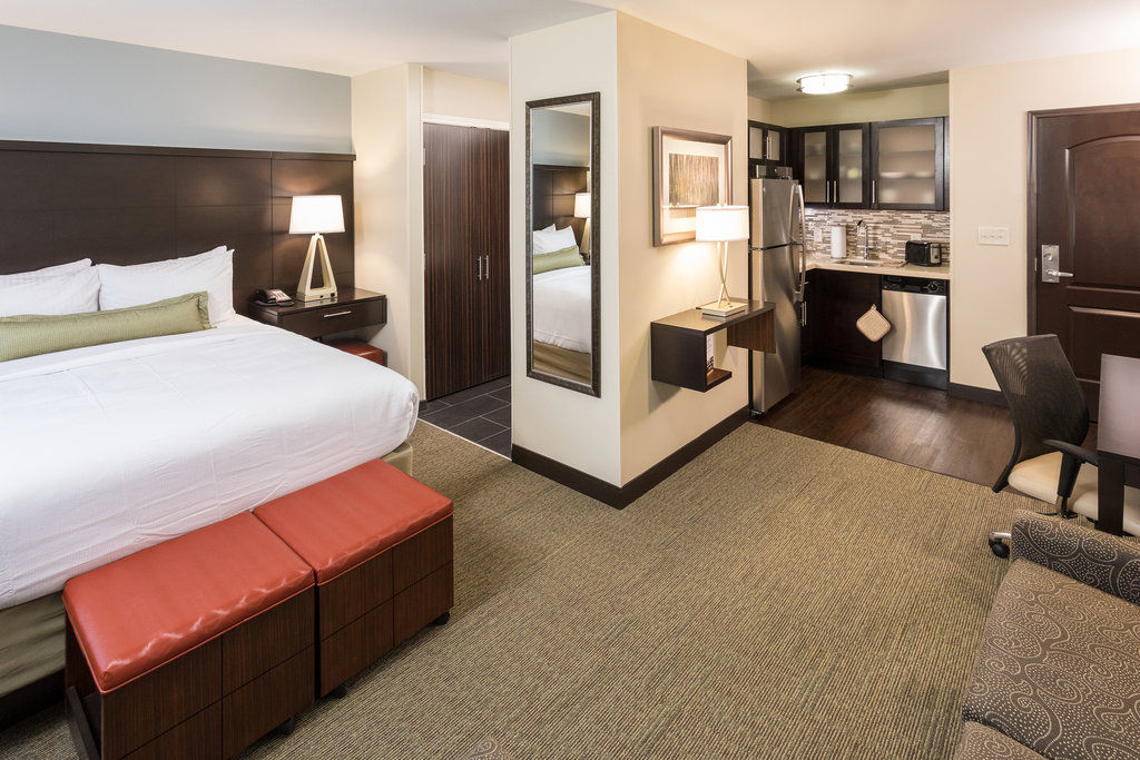 image Relax in your cozy studio featuring a plush queen bed and convenient kitchenette, perfect for your stay.
