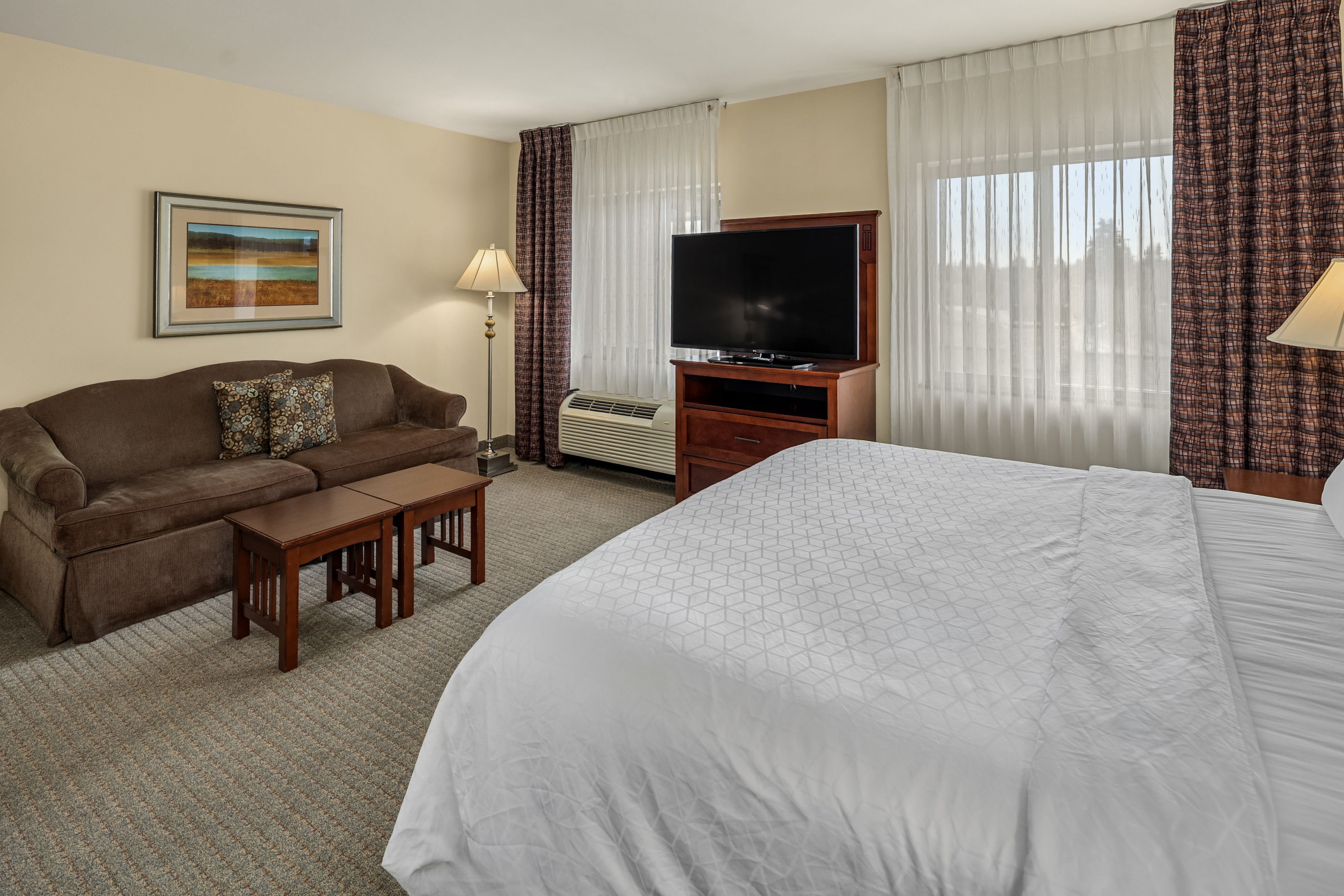 image Bright room with a couch and large window views.