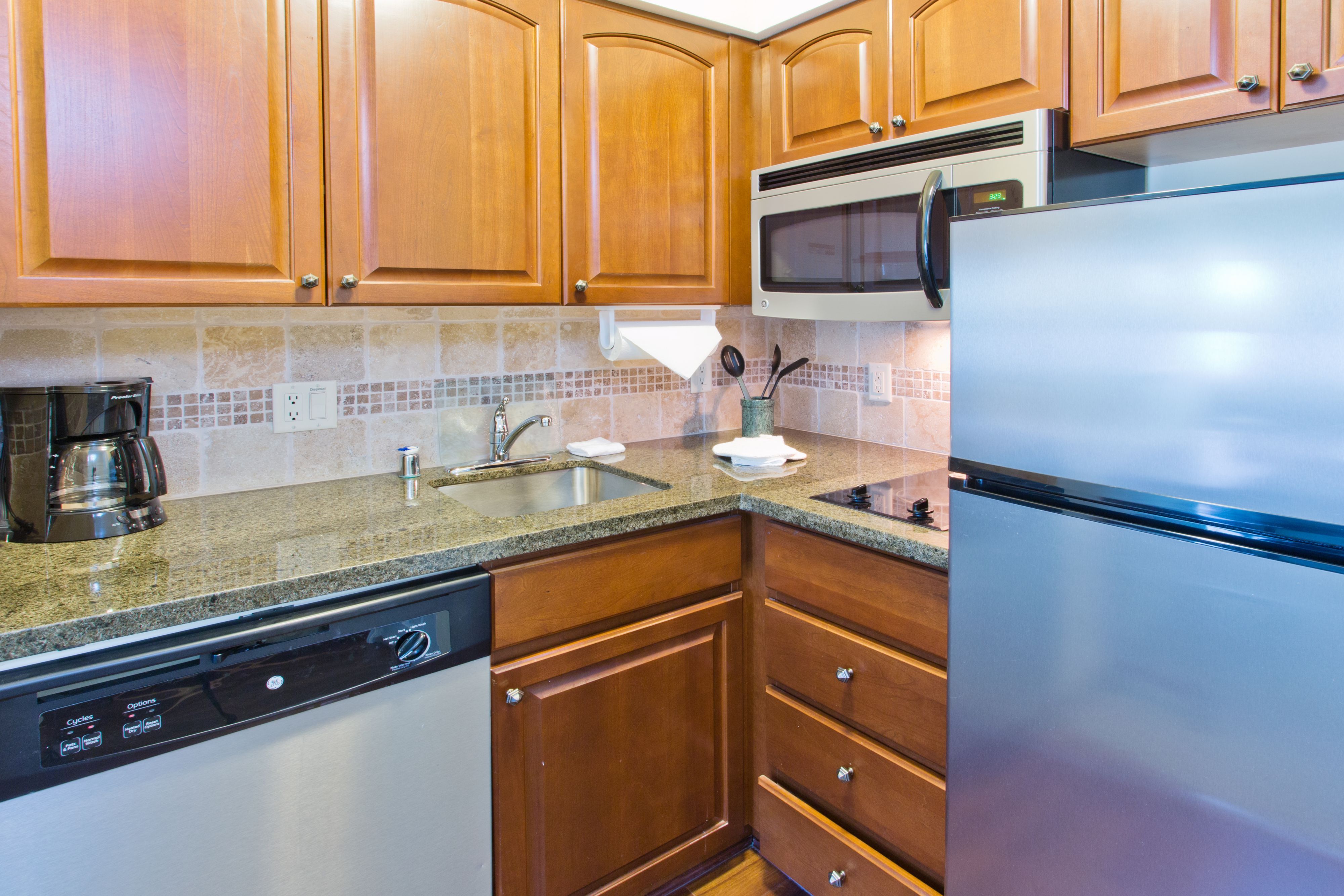 image Modern kitchen featuring wooden cabinets and appliances.
