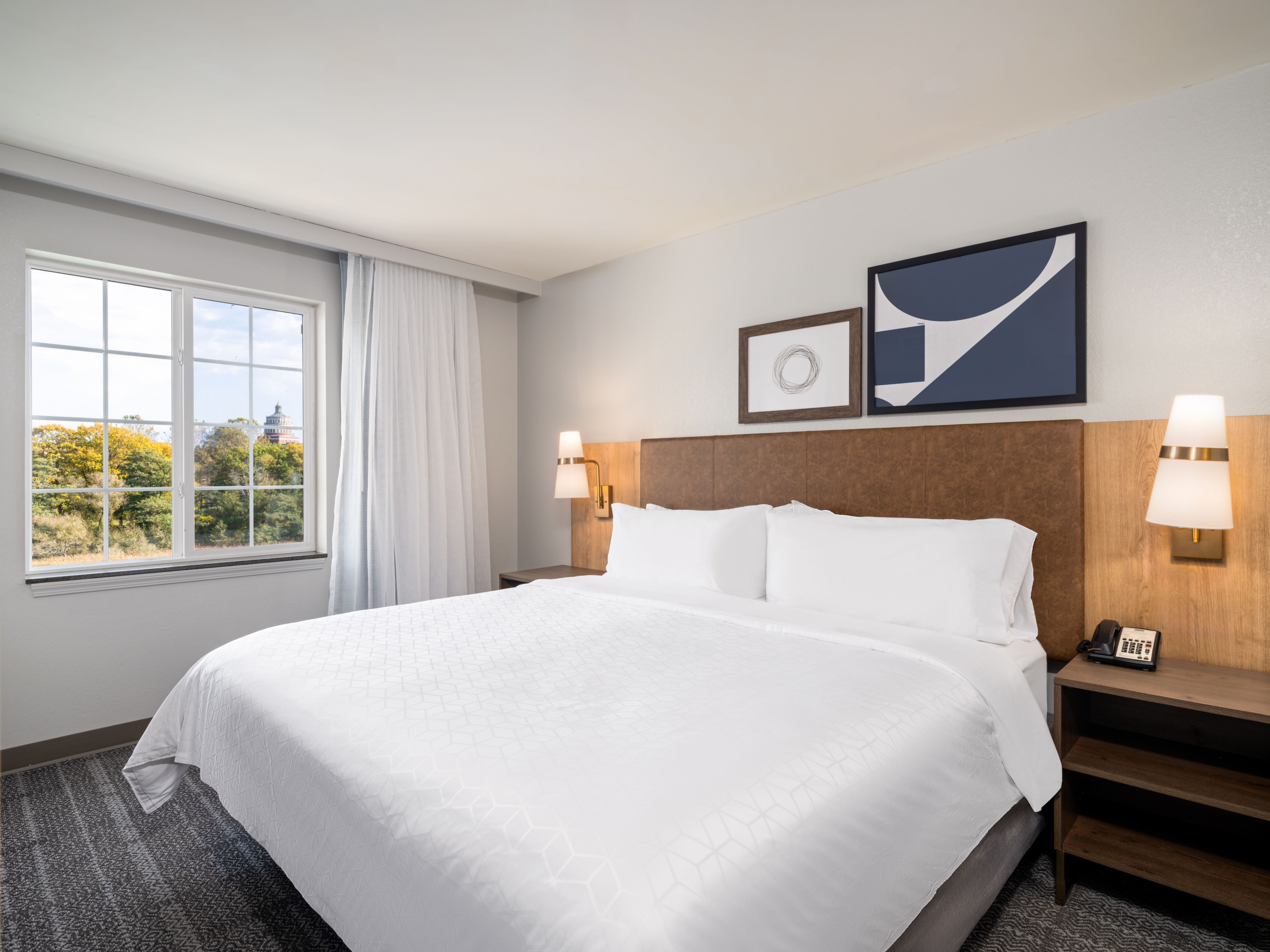 image Bedroom with large bed, window, and artwork
