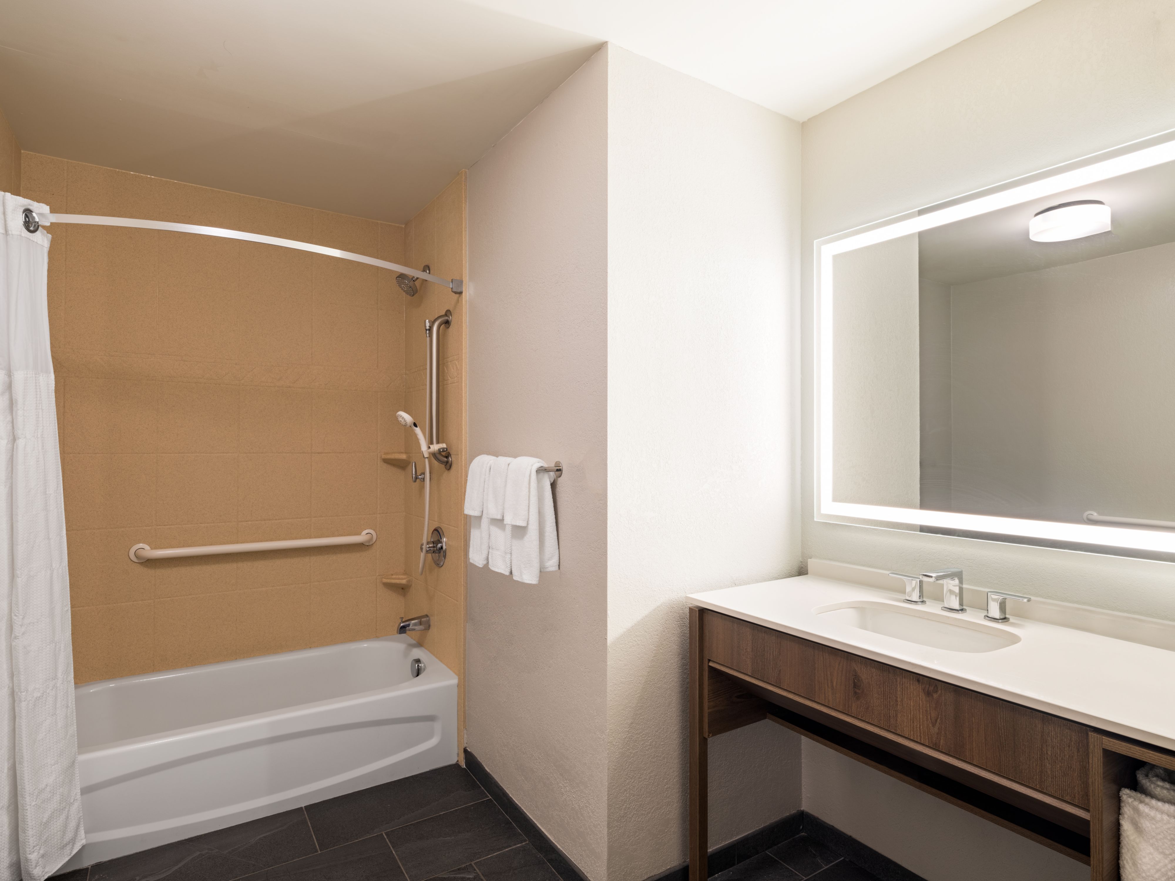 image Bathroom with tub, shower, and mirror