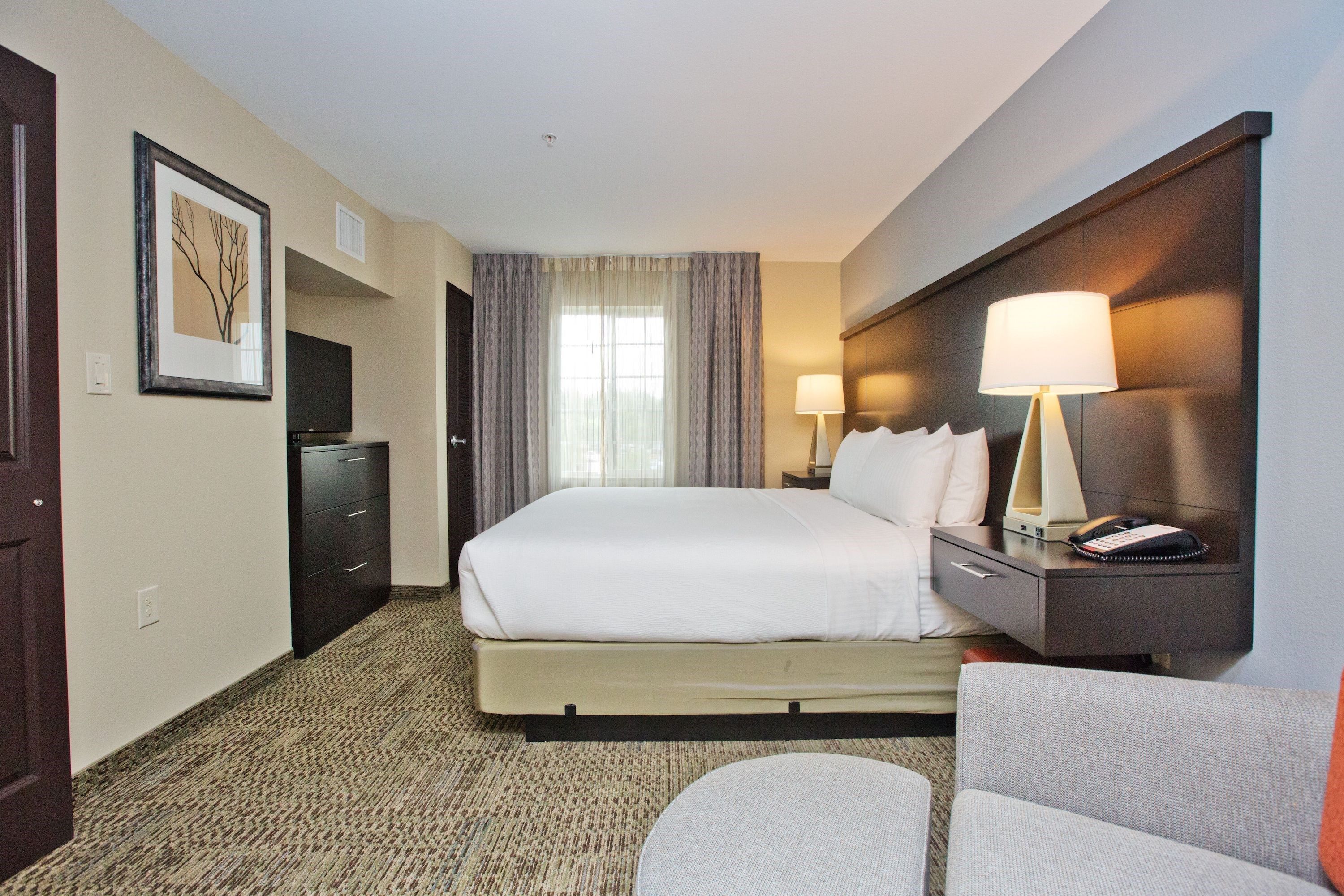image Master bedroom with king bed, bedside lamps, flat-screen TV, and dresser.