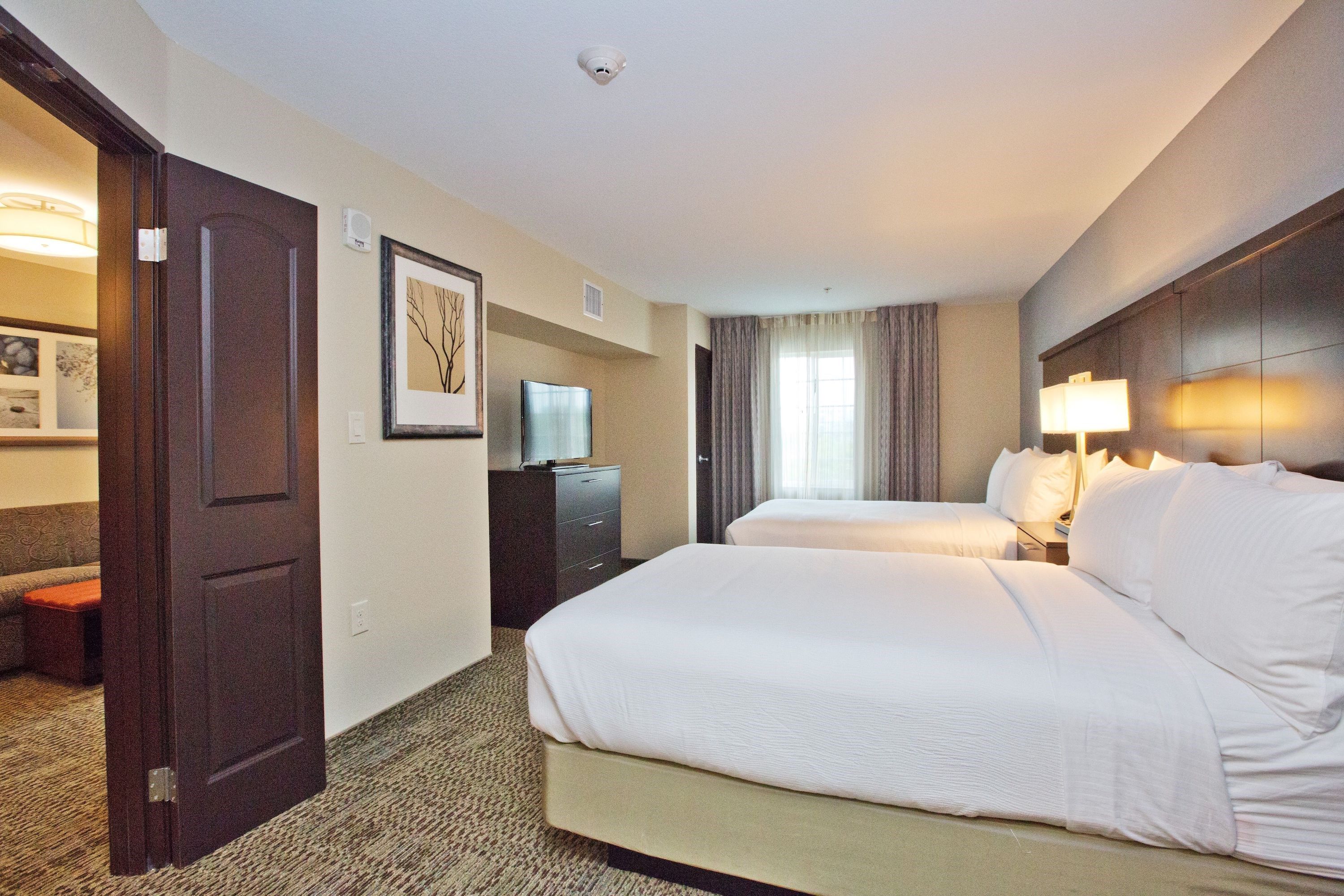 image Second bedroom with two double beds, flat-screen TV, and window.