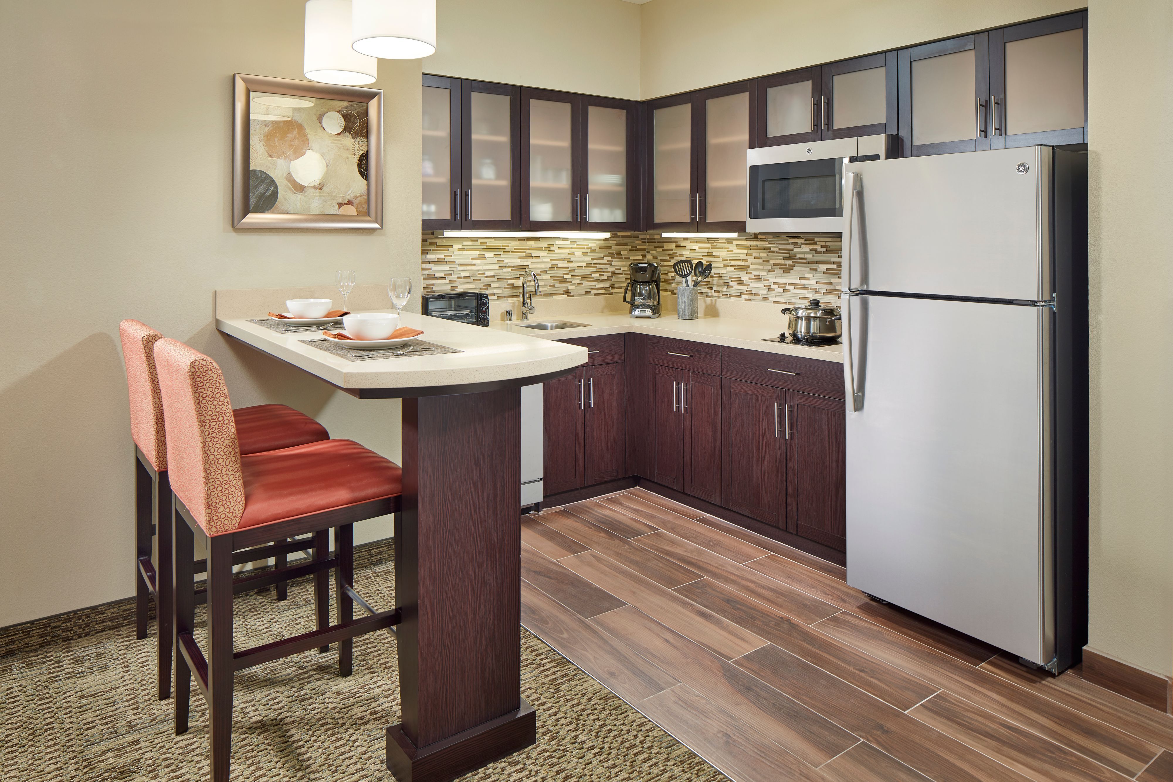 image Full kitchen with dark wood cabinets and stainless steel appliances.
