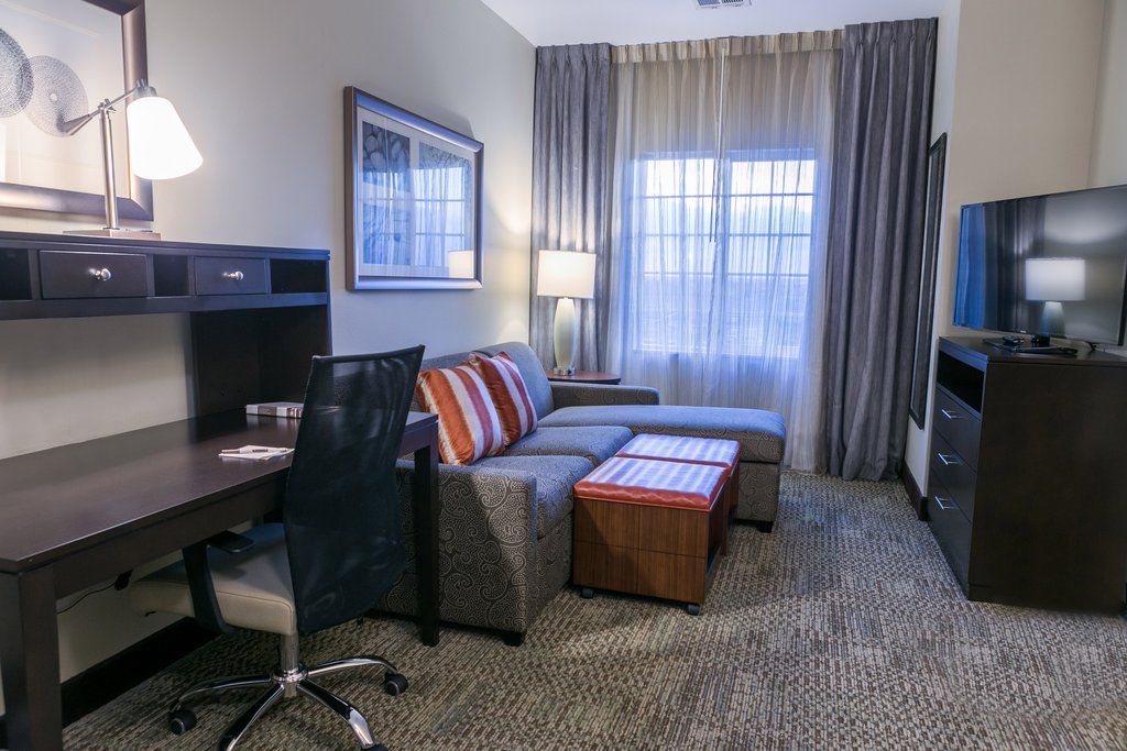image Unwind in the comfortable living area with a work desk, plush seating, and modern furnishings.