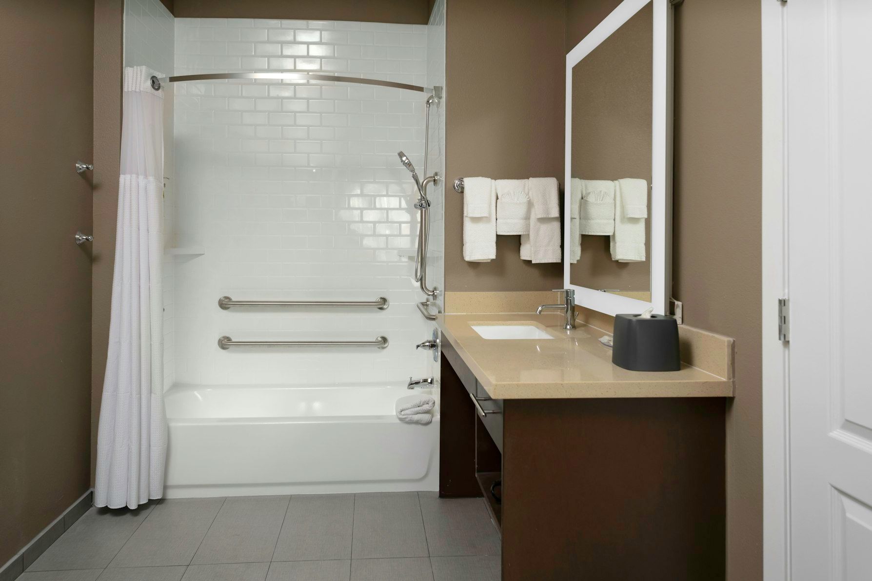 image Experience the convenience of an ADA-accessible bathroom featuring grab bars and a shower-tub combination.