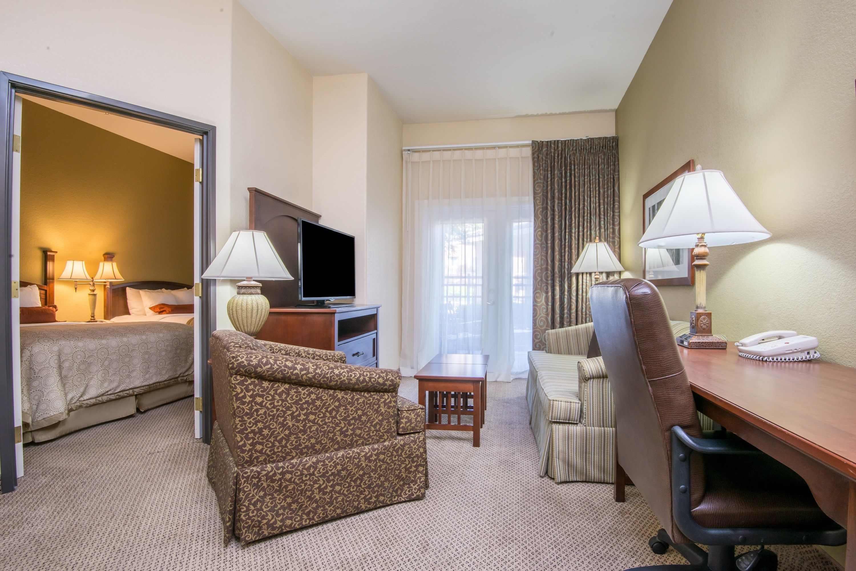 image Living area with sofa, desk, and television.