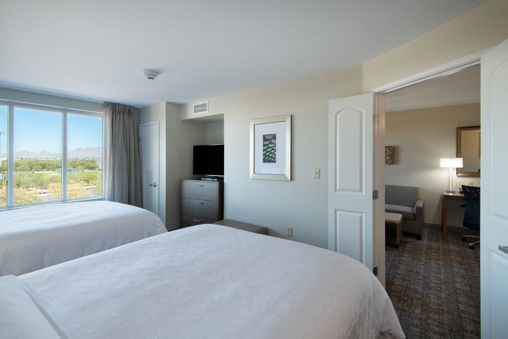 image Two queen beds with white bedding and large windows framing views of the Scottsdale mountain landscape
