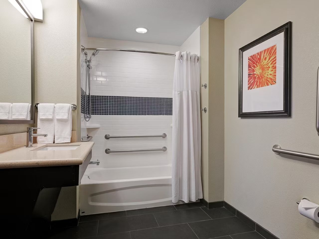 image Accessible bathroom featuring a spacious tub and grab bars.