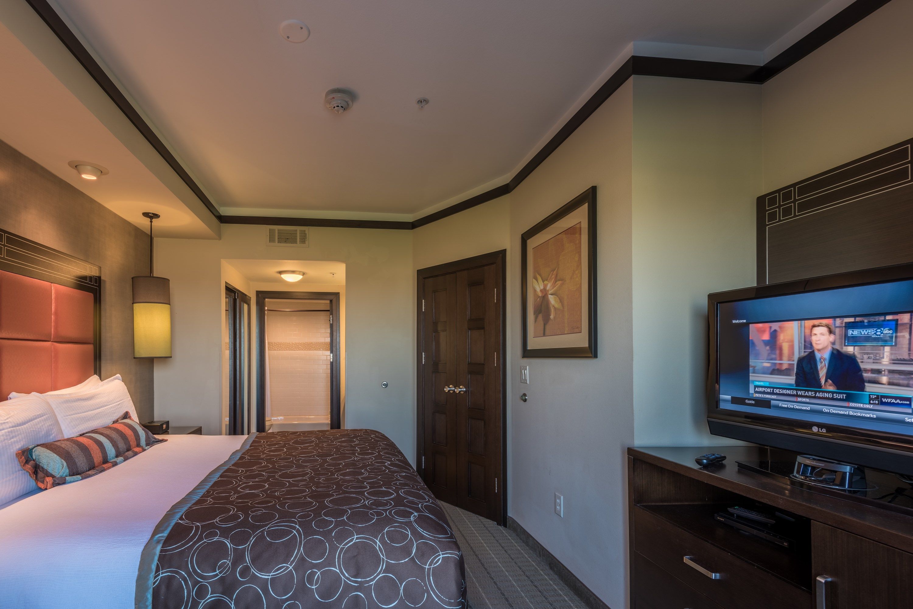 image Bedroom with queen bed, flat-screen TV, and artwork.