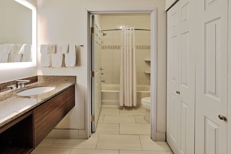 image Accessible bathroom with shower-tub combo and generous storage space