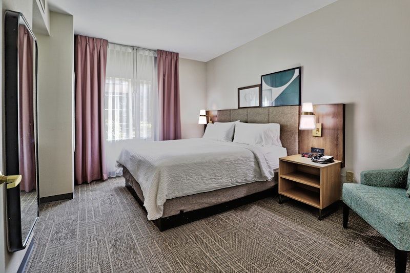 image King bedroom with armchair and bright window for restful sleep