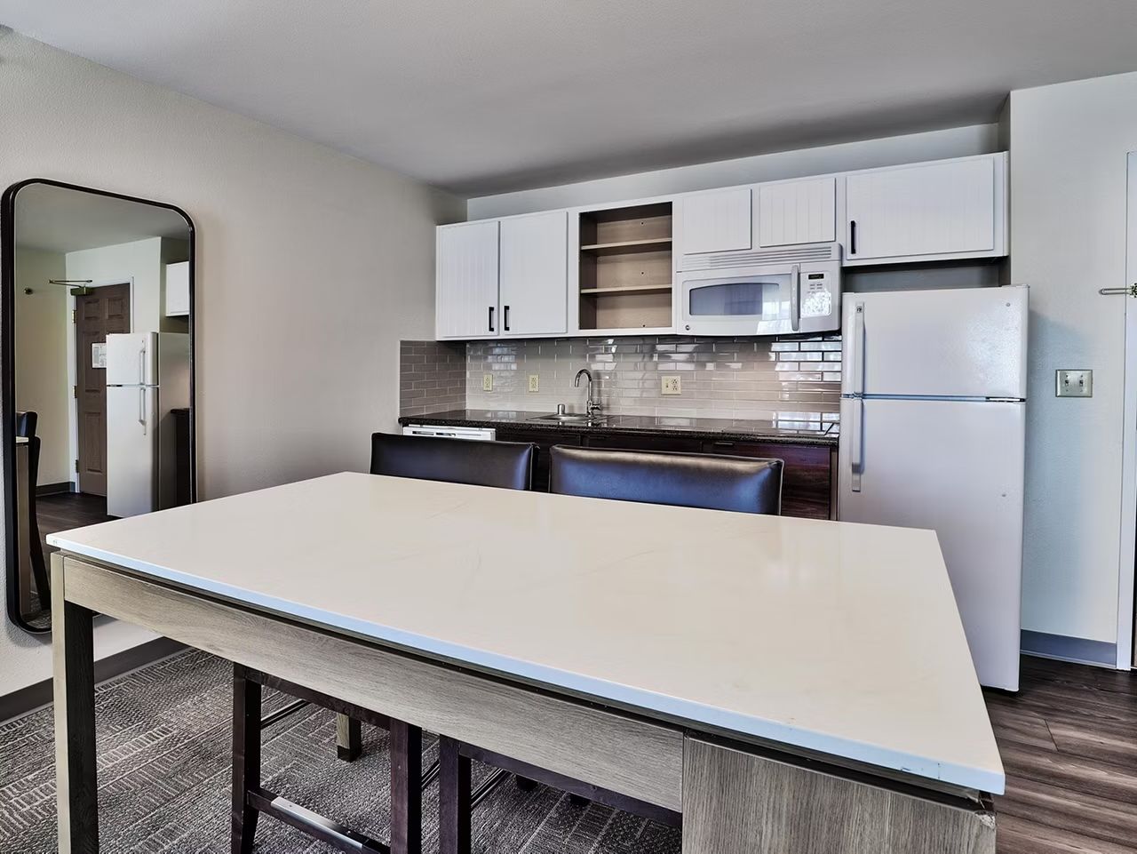 image White cabinetry and stainless steel appliances in the fully equipped kitchen — stove, microwave, dishwasher, fridge, and coffee maker included
