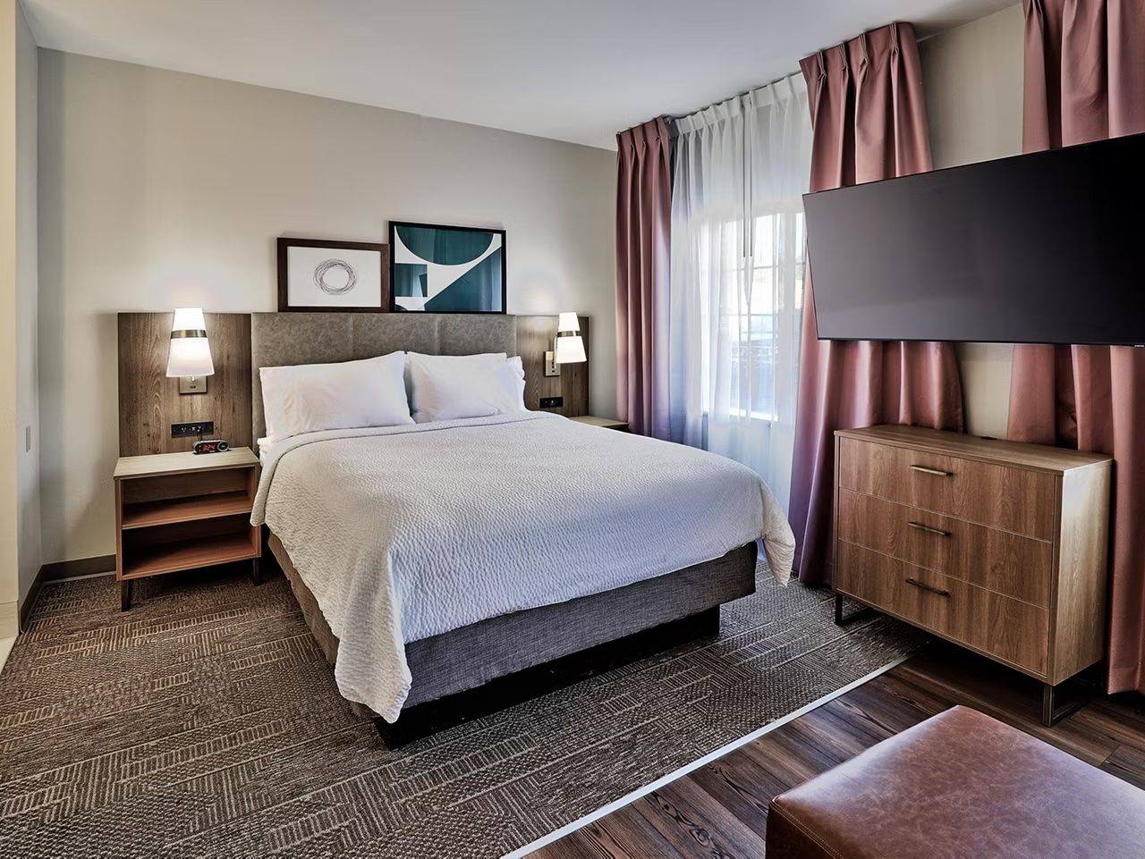 image Natural light flows into the studio, highlighting the soft textures of the queen bed and modern furnishings