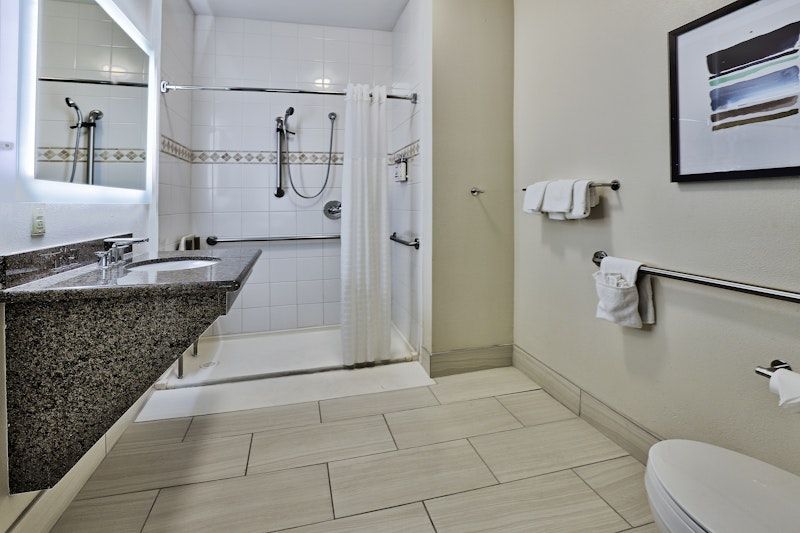 image Accessible bathroom with roll-in shower and dual sink vanity