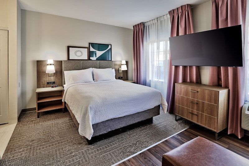 image Studio with queen bed, television, and wooden furniture