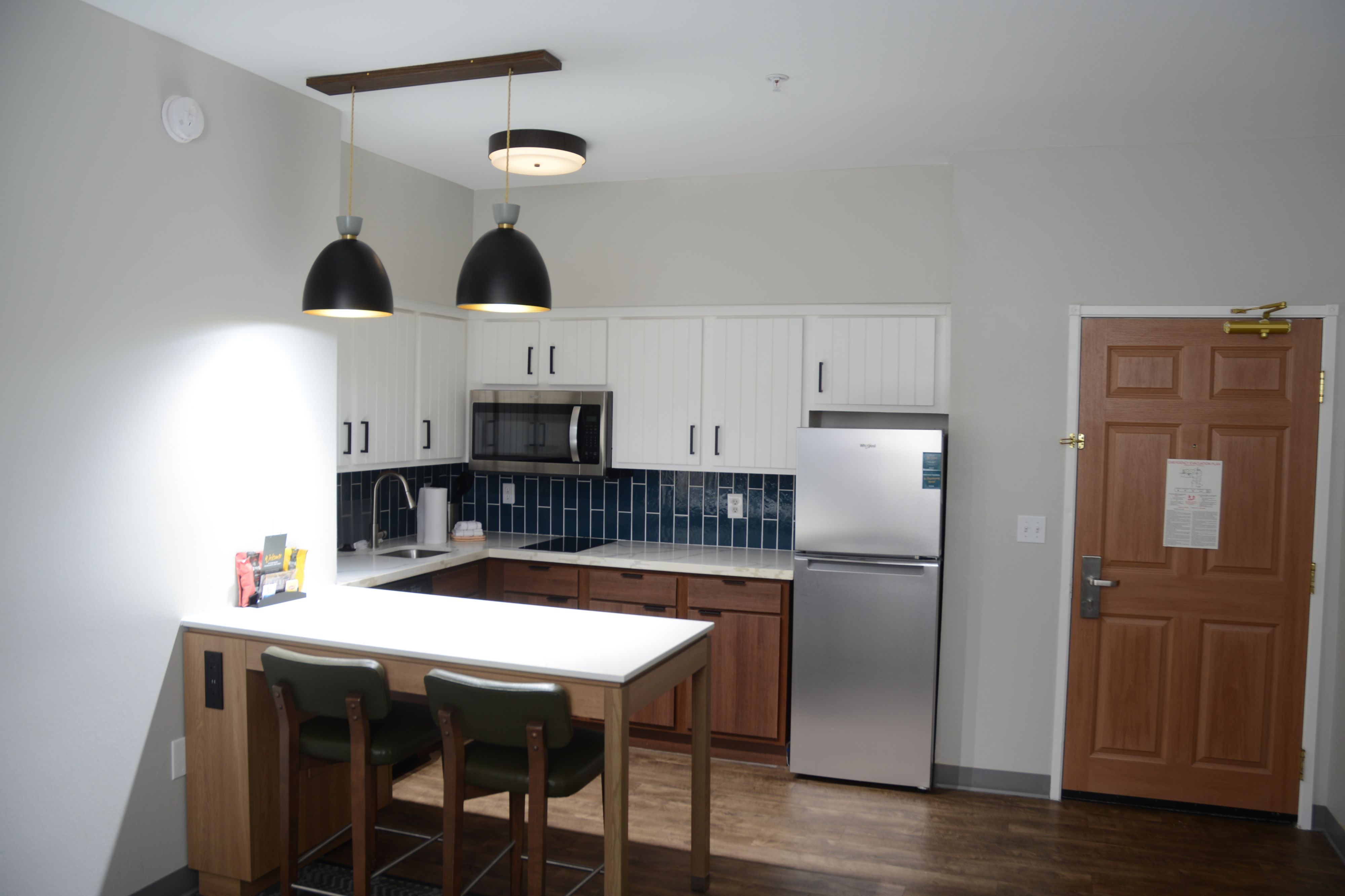 image Modern kitchen area with bar seating and full appliances.