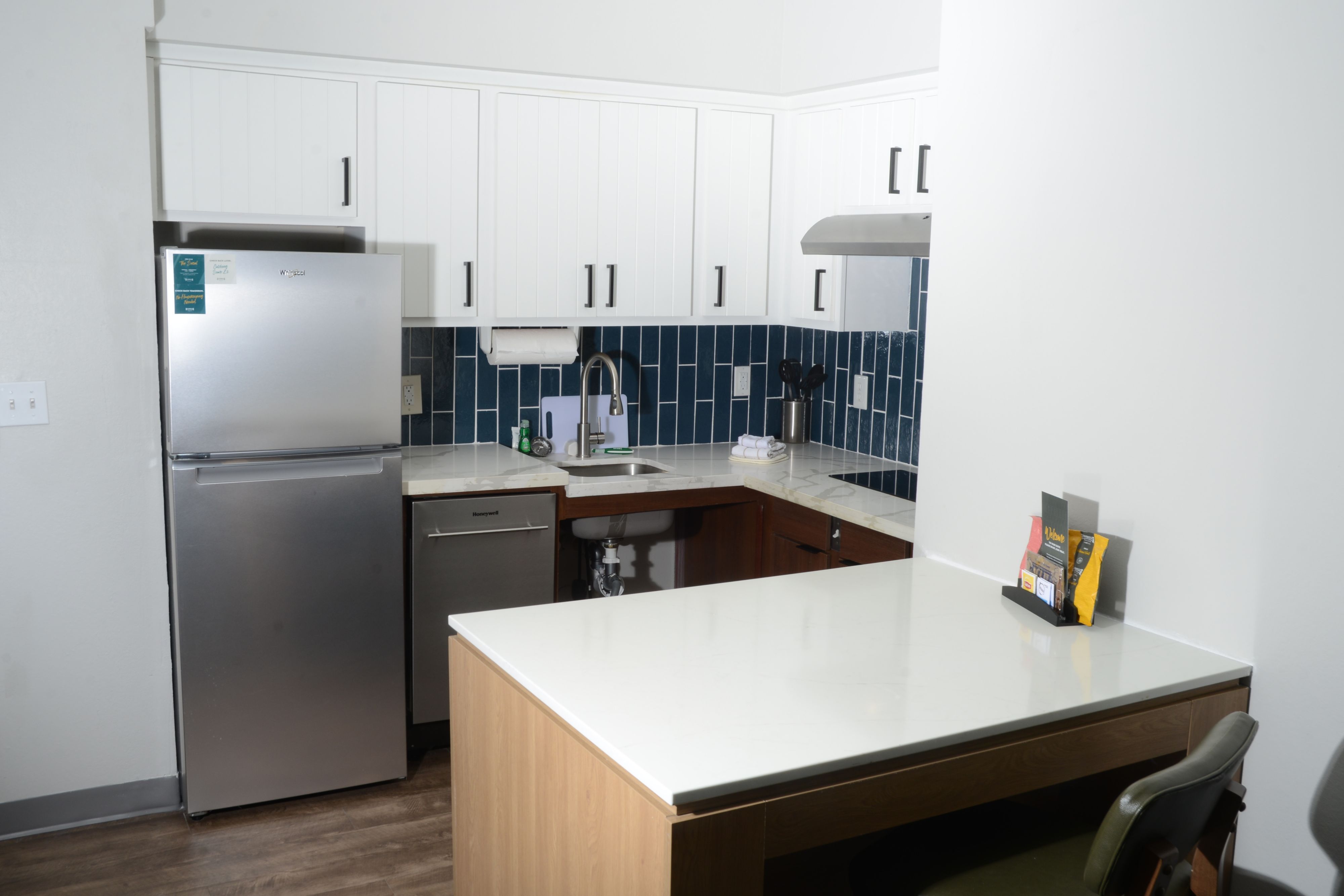 image Modern kitchen with stainless steel appliances and blue tile accents.