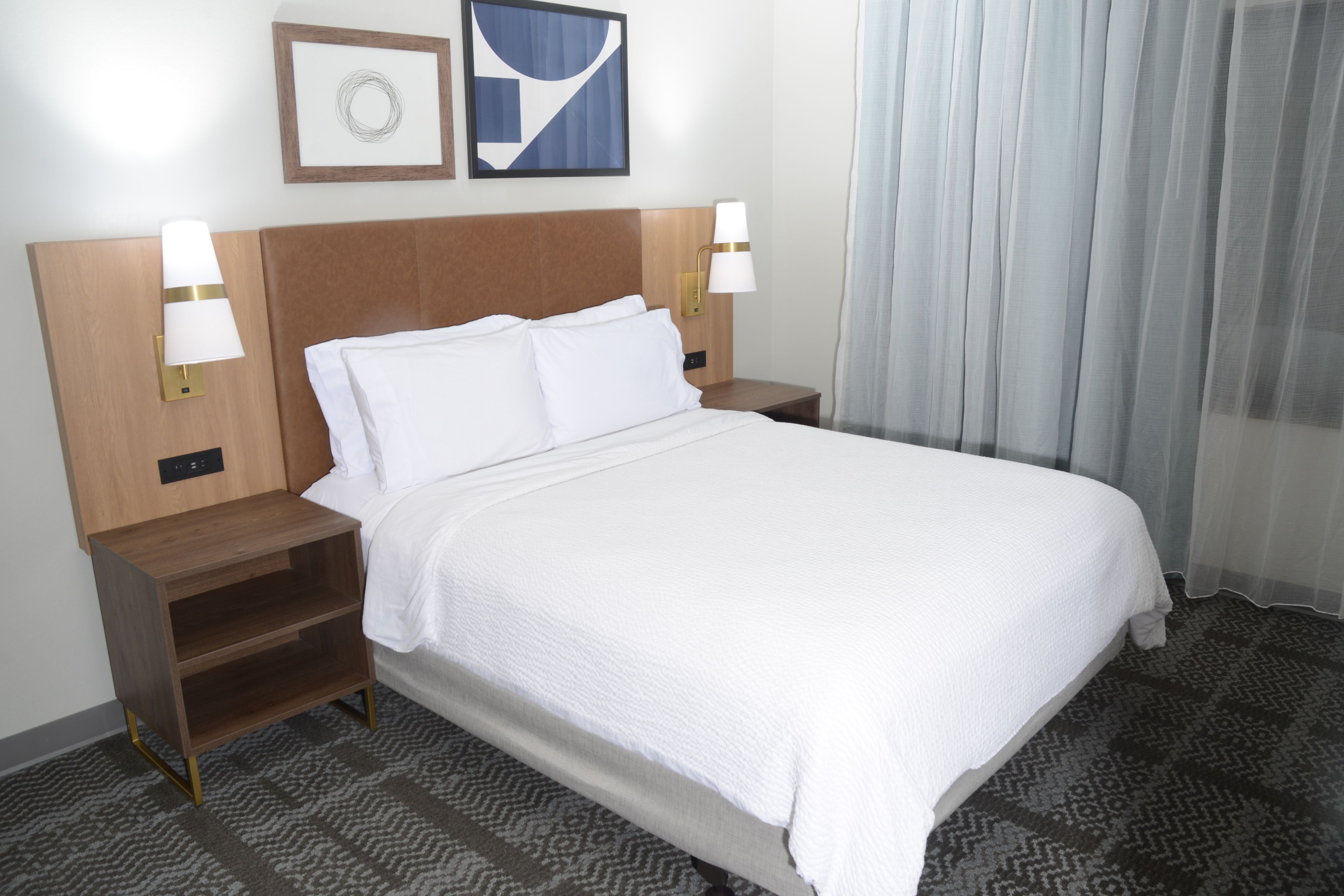image Comfortable bedroom with modern furnishings and artistic wall decor.