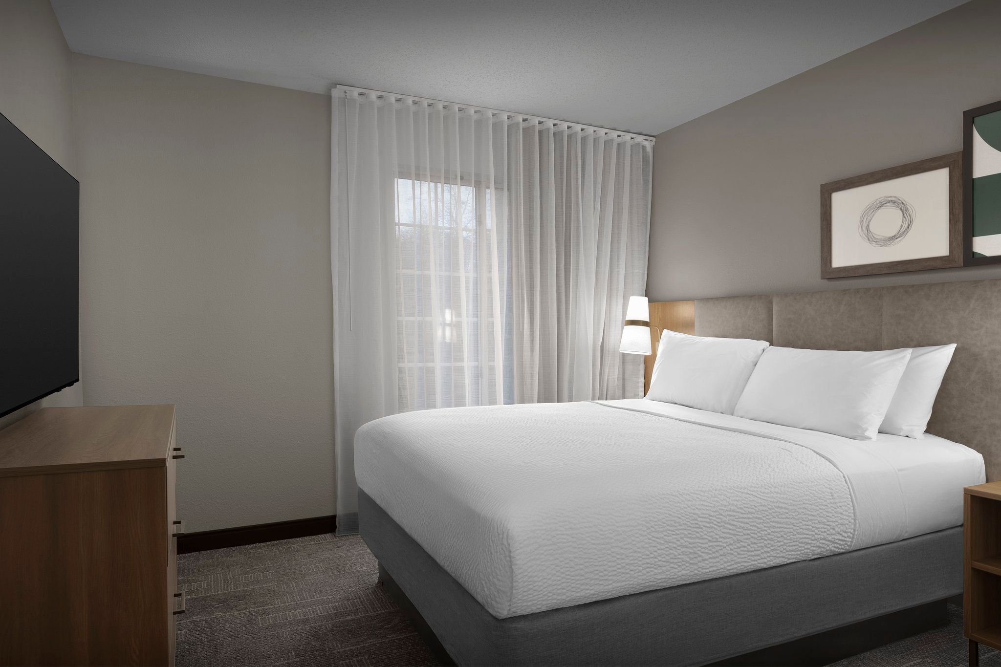 image Drift into a peaceful slumber on crisp, white linens in a cozy, well-lit master bedroom.