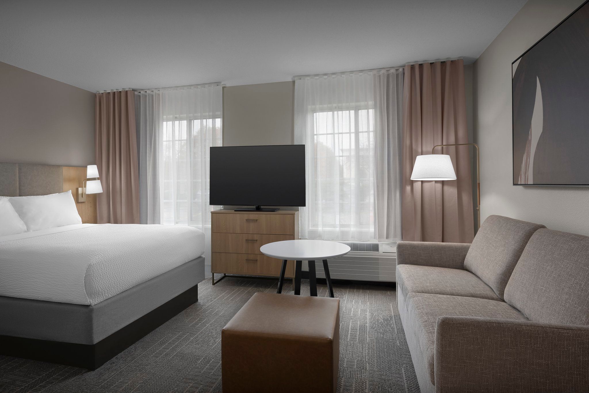 image Unwind by the large flatscreen, surrounded by natural light in this inviting room.