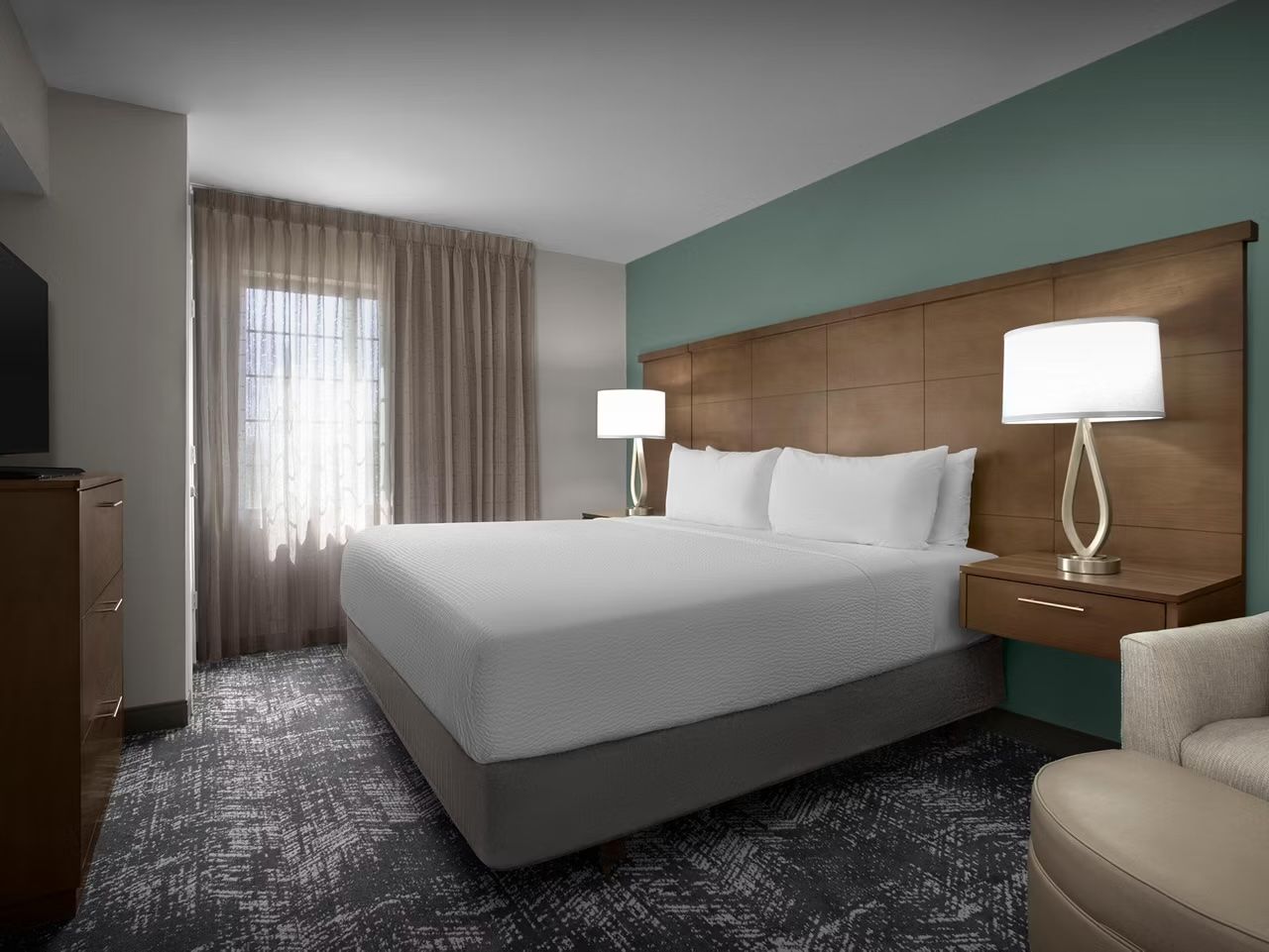 image Comfortable king bedroom with fresh linens and lamps.