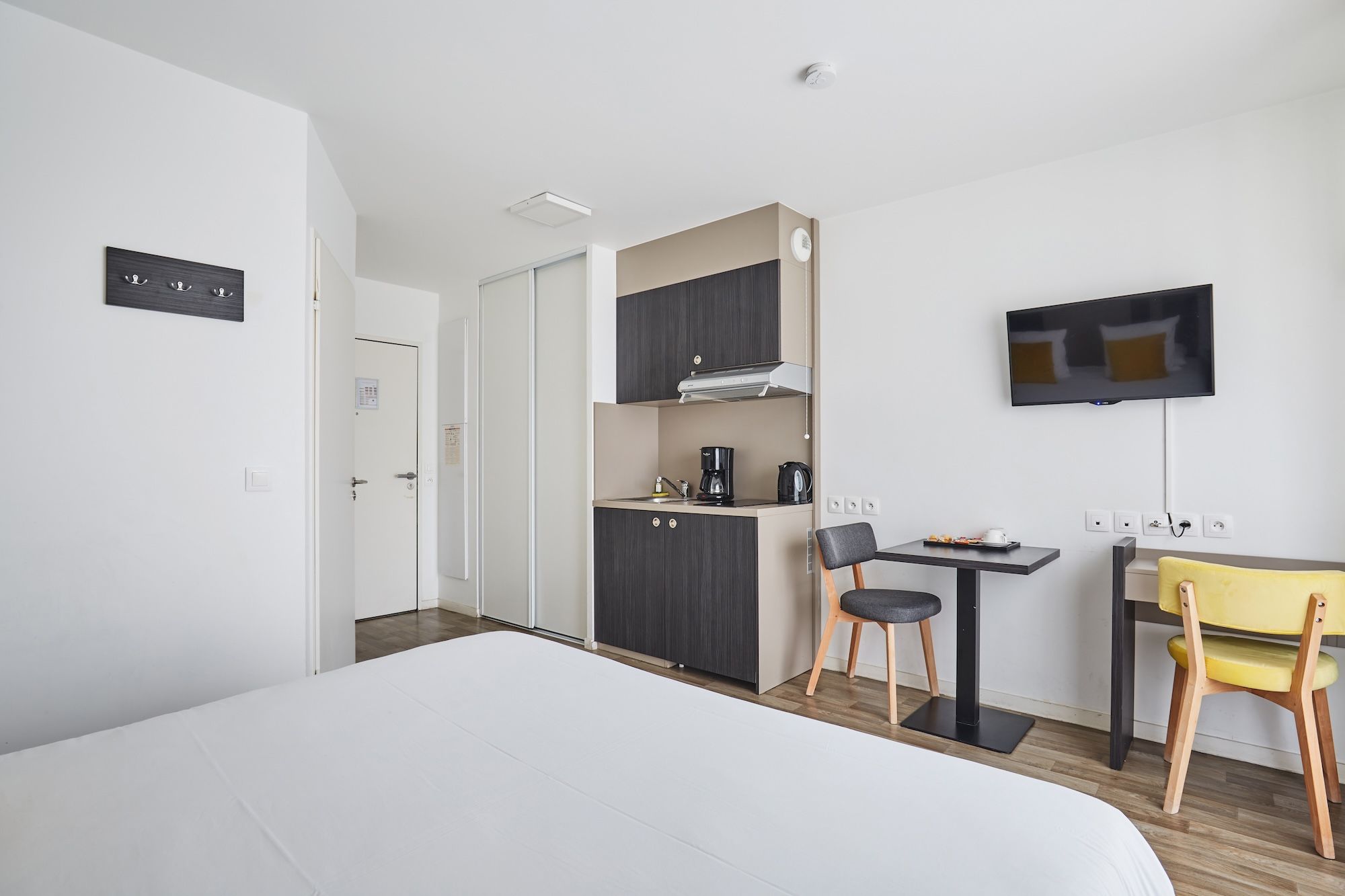 image Discover this inviting space complete with a functional kitchenette, a designated dining area, and modern amenities for a pleasant stay.