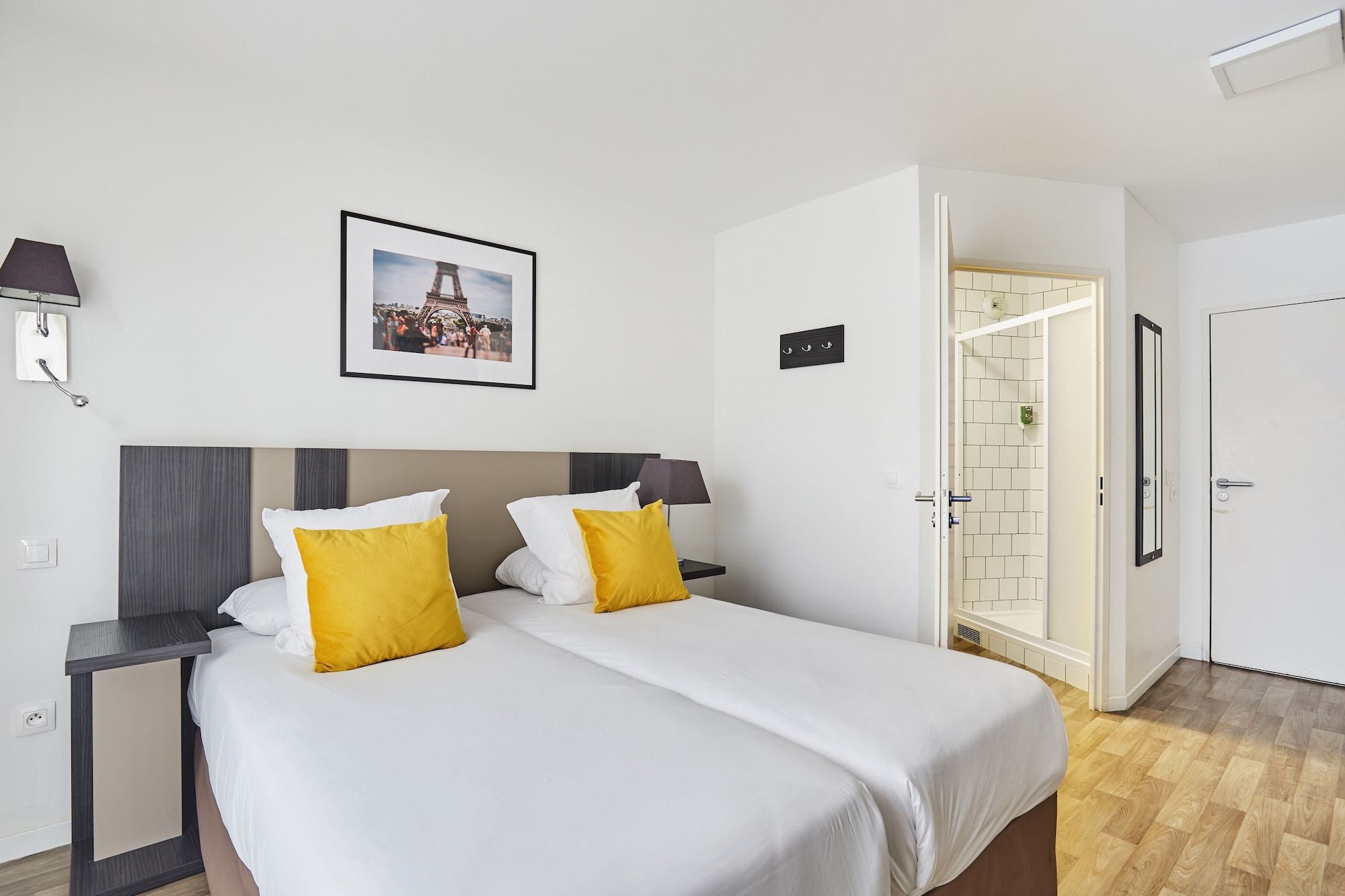 image The bedroom provides a relaxed atmosphere with two zip beds, soft lighting from wall lamps, and an en-suite bathroom that can be seen in the background.