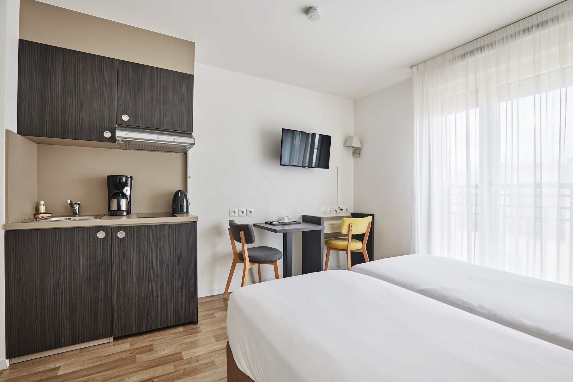 image The well-equipped kitchenette includes electric hobs and a coffee maker, while a small dining area with stylish chairs is ideal for meals or work.
