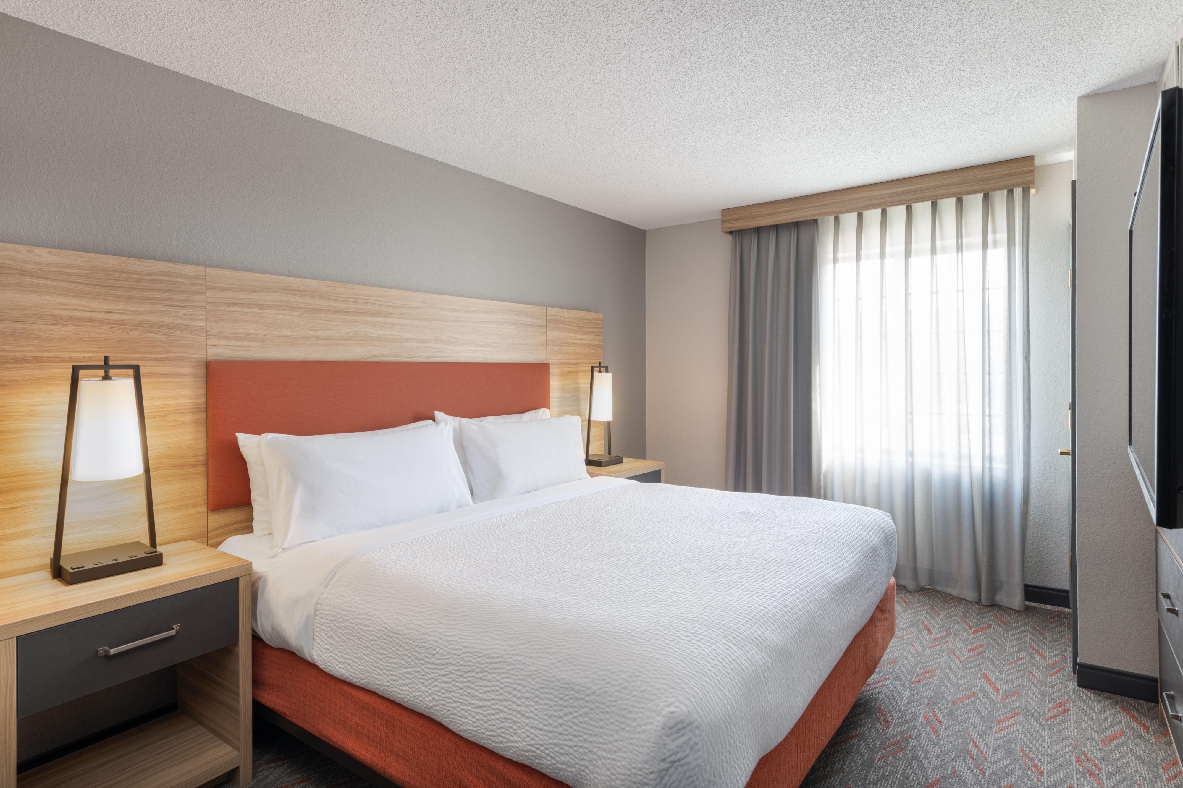 image Comfortable bedroom with modern furnishings and ample natural light.