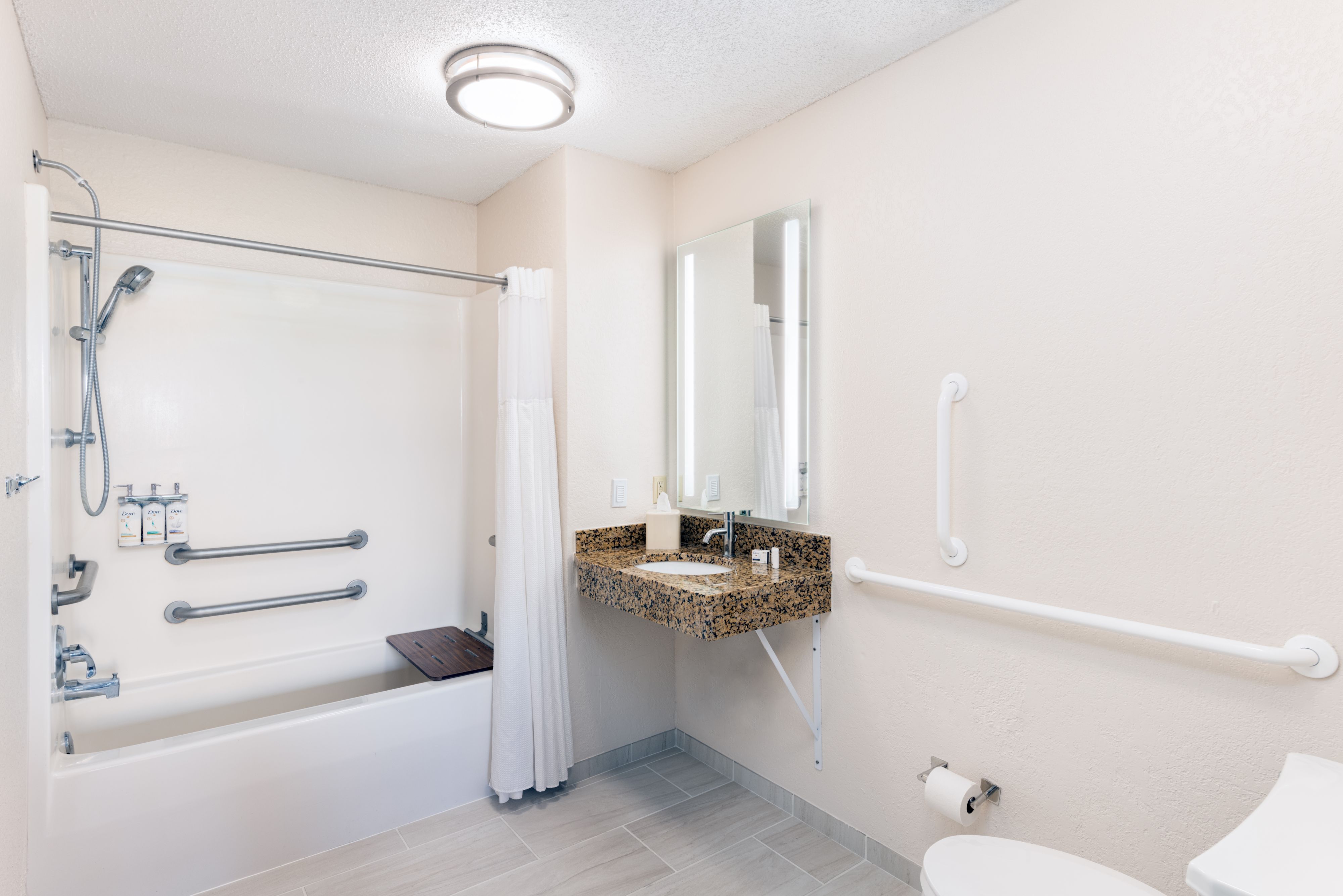 image Accessible bathroom with shower-tub combo and grab bars.
