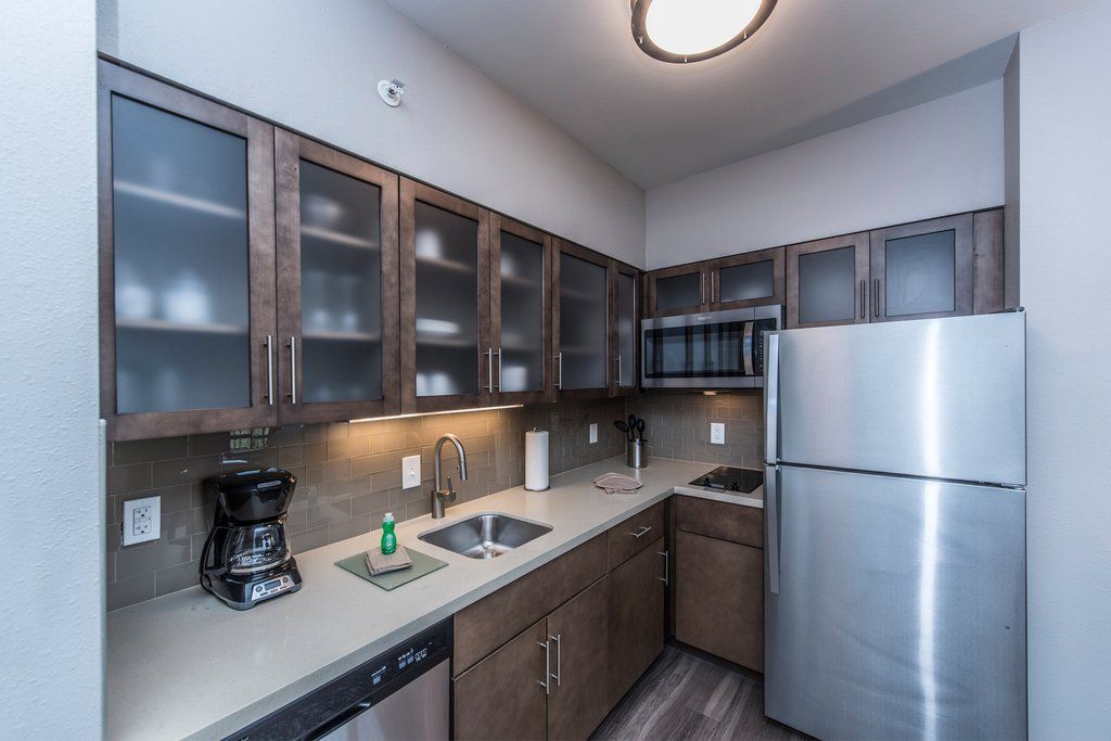 image Compact kitchen with stainless steel appliances and cabinetry.