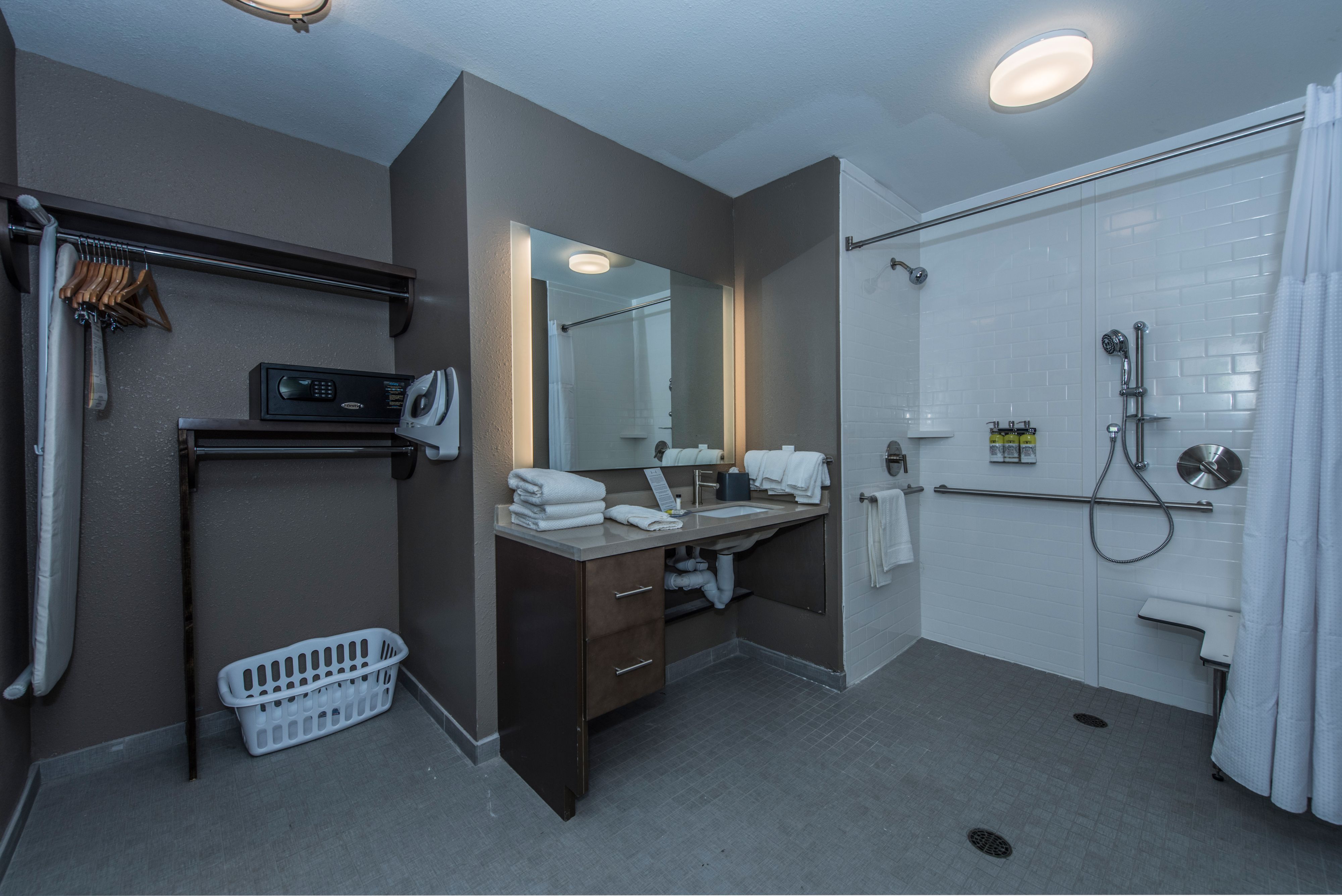 image Accessible bathroom with walk-in shower, sink, and storage.