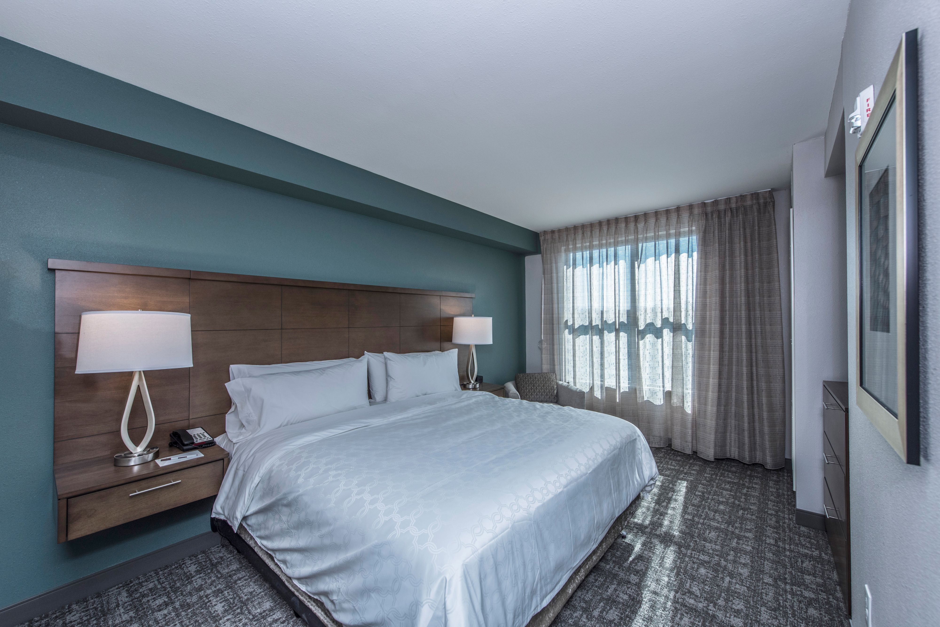 image Cozy bedroom featuring a king-sized bed and natural light.