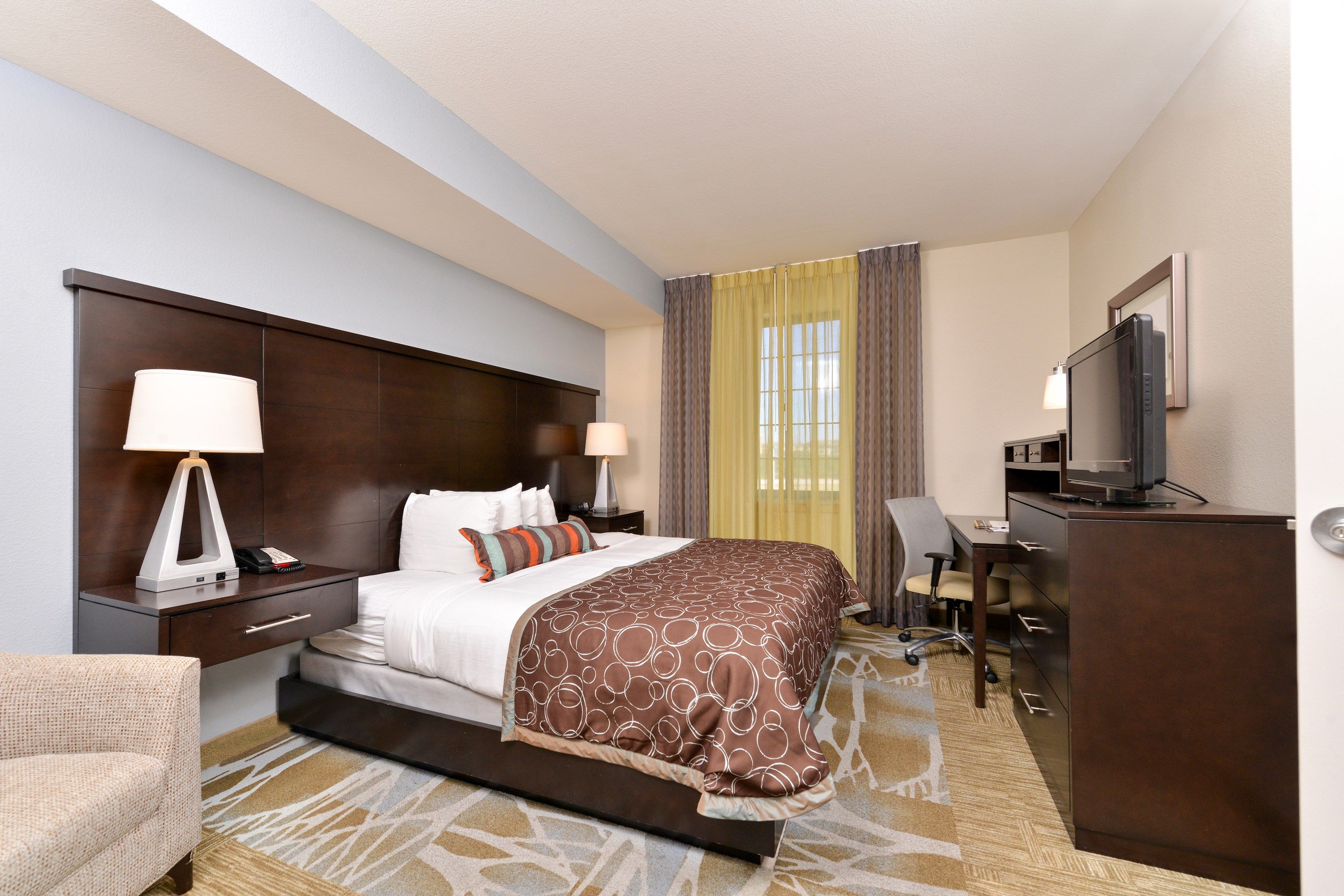 image Bedroom with queen bed, desk, and flat-screen TV.