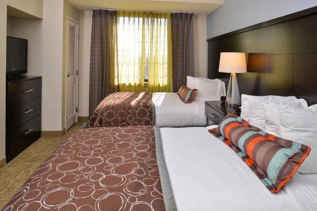 image Bedroom with double beds, clothing storage, and flat-screen TV.