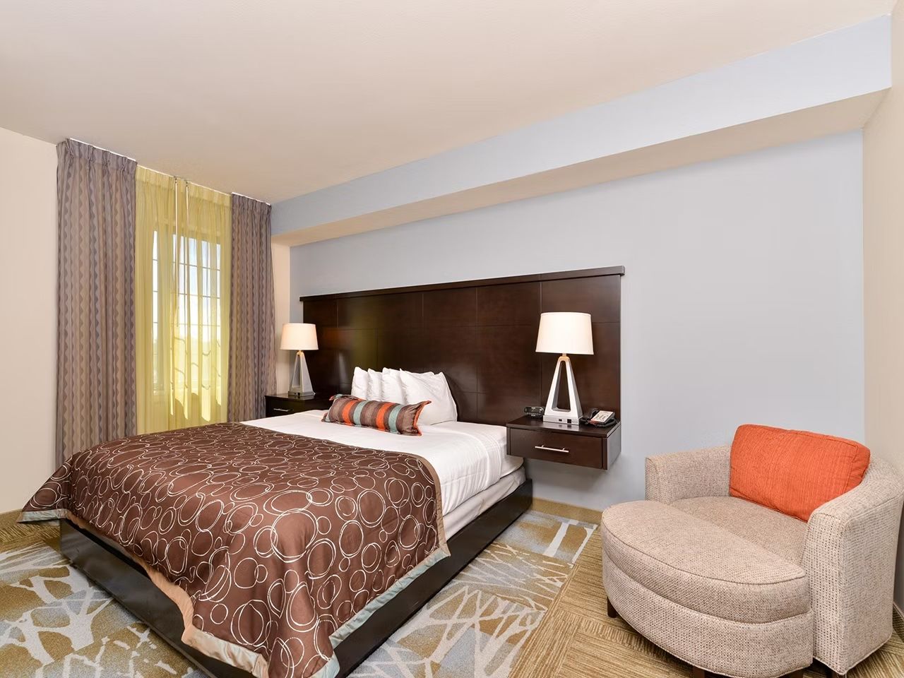 image Bedroom with queen bed, nightstands, and an armchair.