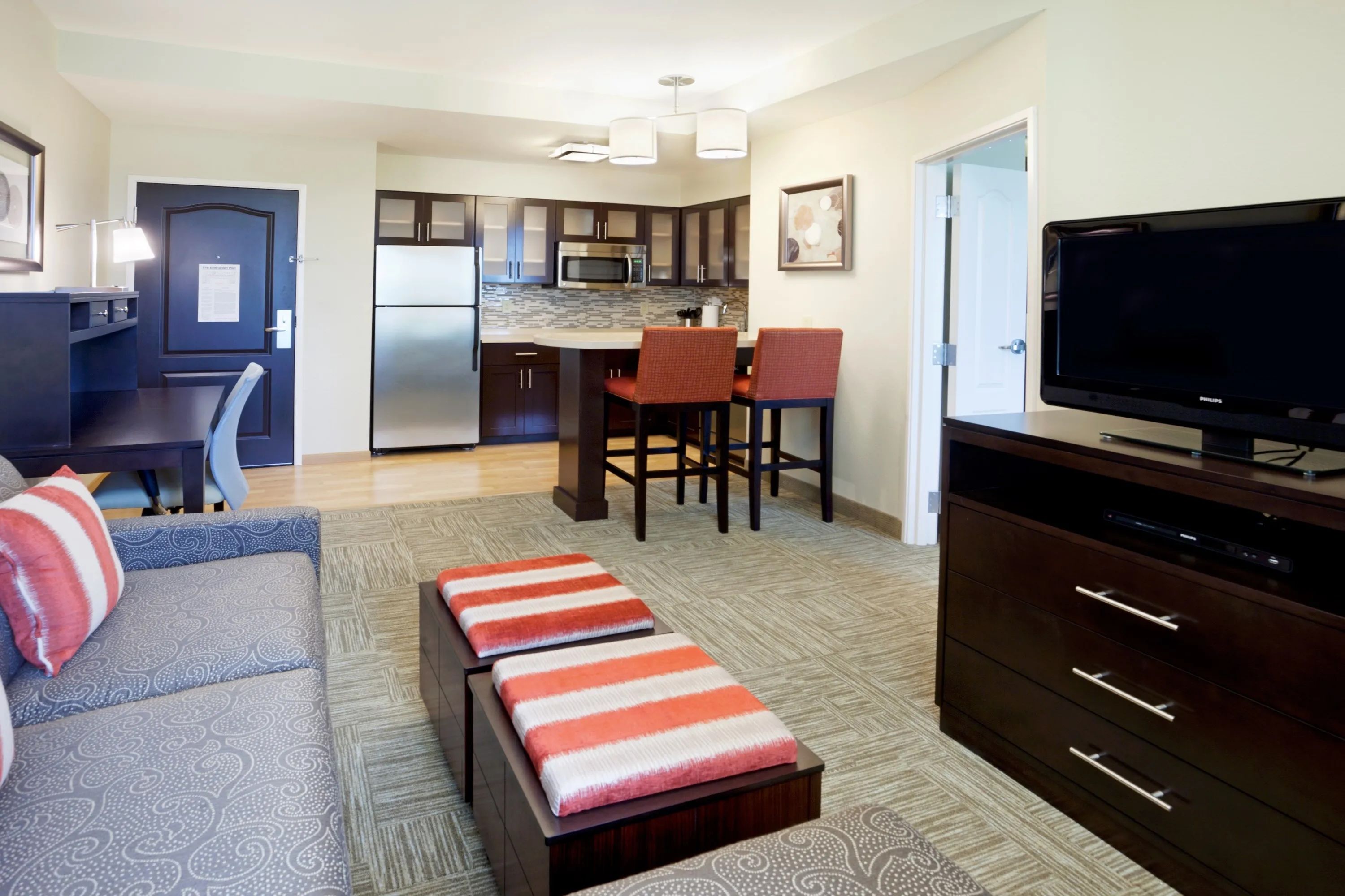 image Living area with kitchen, seating, and dining table.