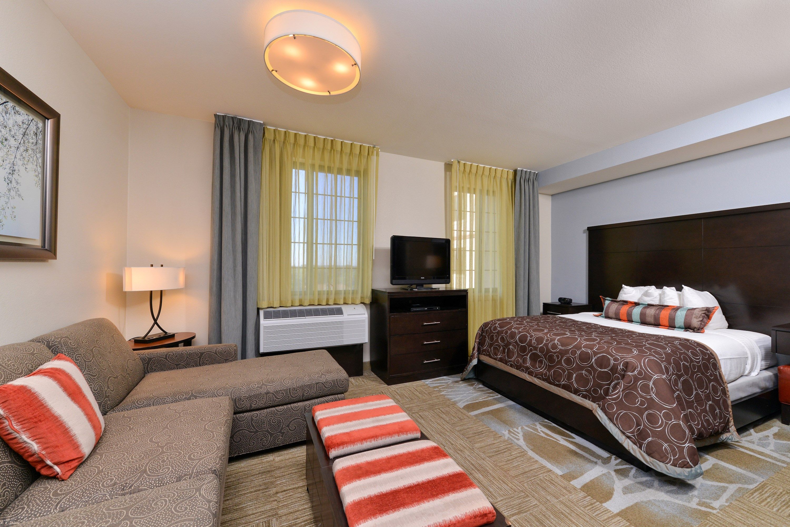 image Studio suite with queen bed, sofa, and flat-screen TV.