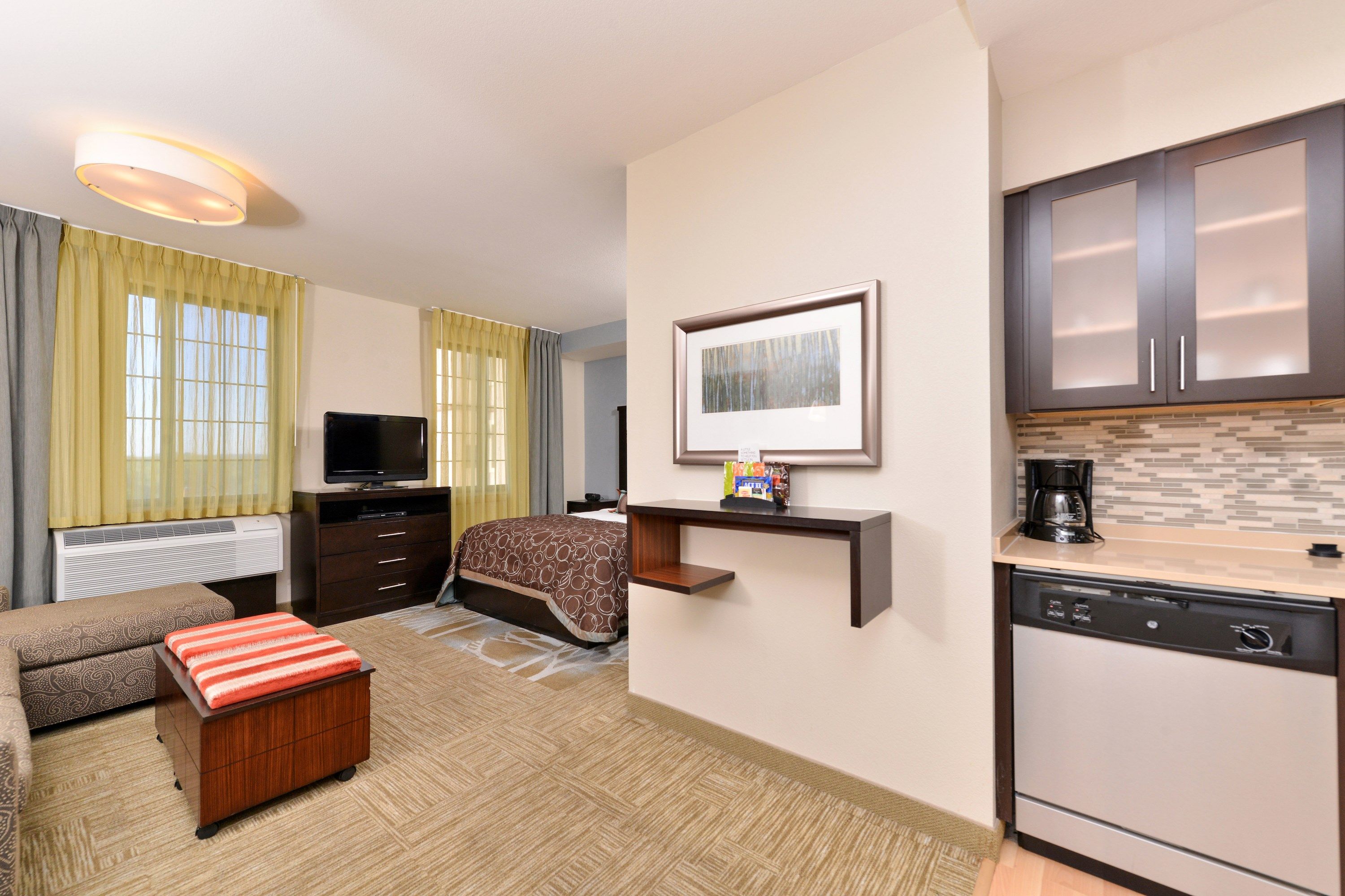 image Studio suite with kitchen, sofa, bed, and TV.