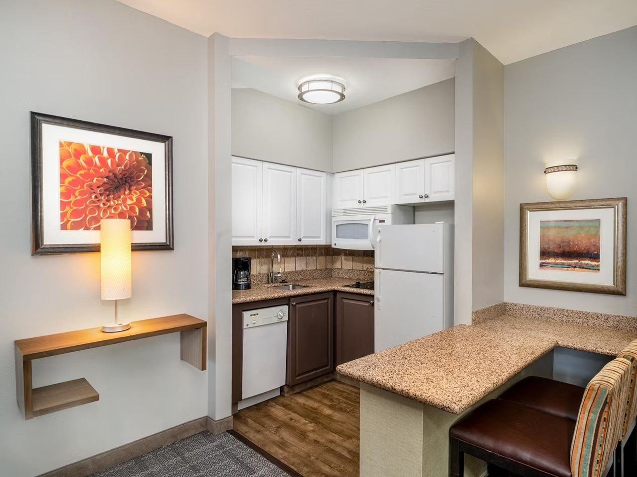 image Kitchen area with countertop, appliances, and floral artwork